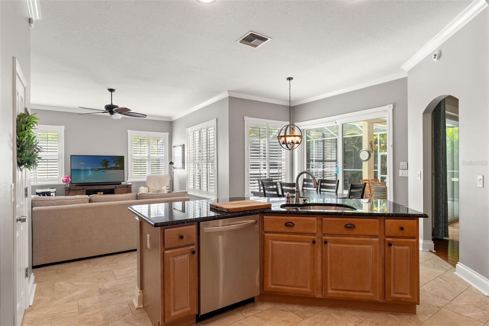 Ideal for modern living, this layout connects the kitchen, dining area, and living space—flooded with natural light from surrounding windows and sliding glass doors.