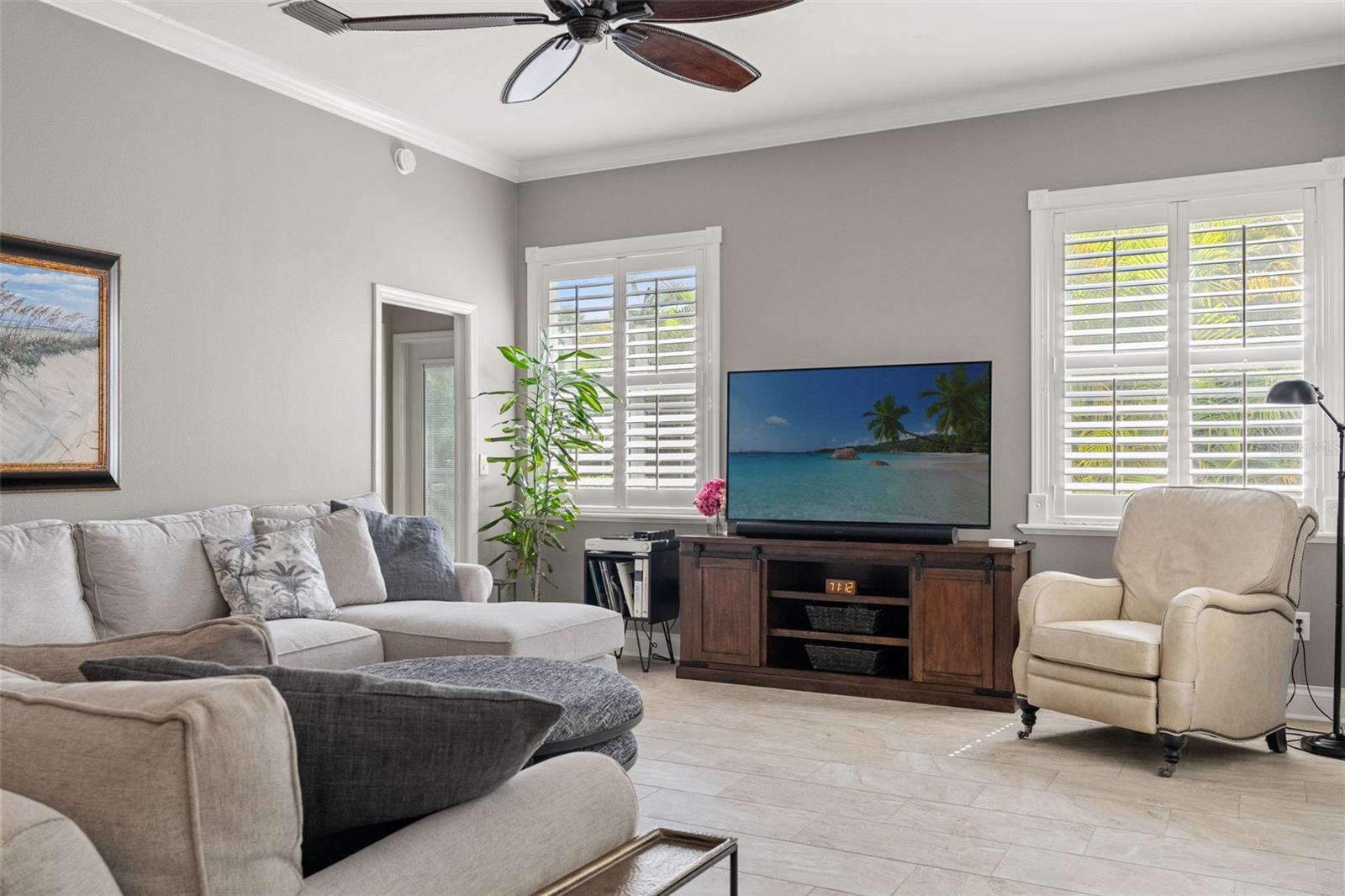 Large windows frame the media area and add a sunny, airy feel to the space while offering a view of the lush backyard.