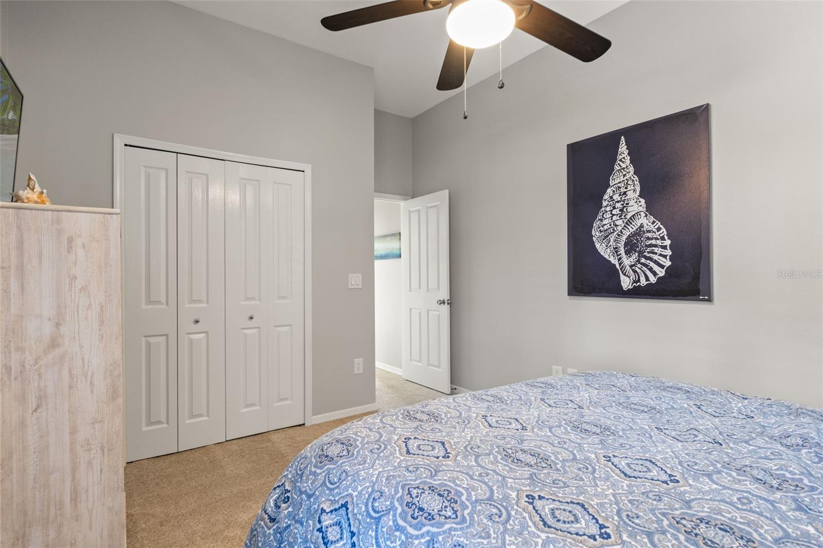 This second angle highlights a double closet, ceiling fan, and neutral finishes, creating a relaxing and functional retreat.