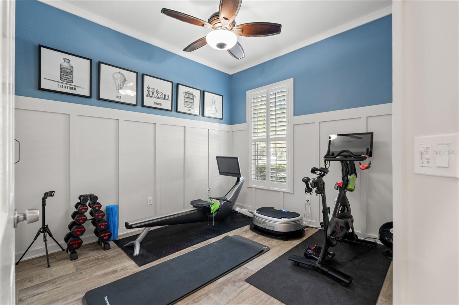 Designed with functionality in mind, this guest room includes board-and-batten wall detailing, luxury vinyl plank flooring, and space for a home gym, office or bedroom setup.