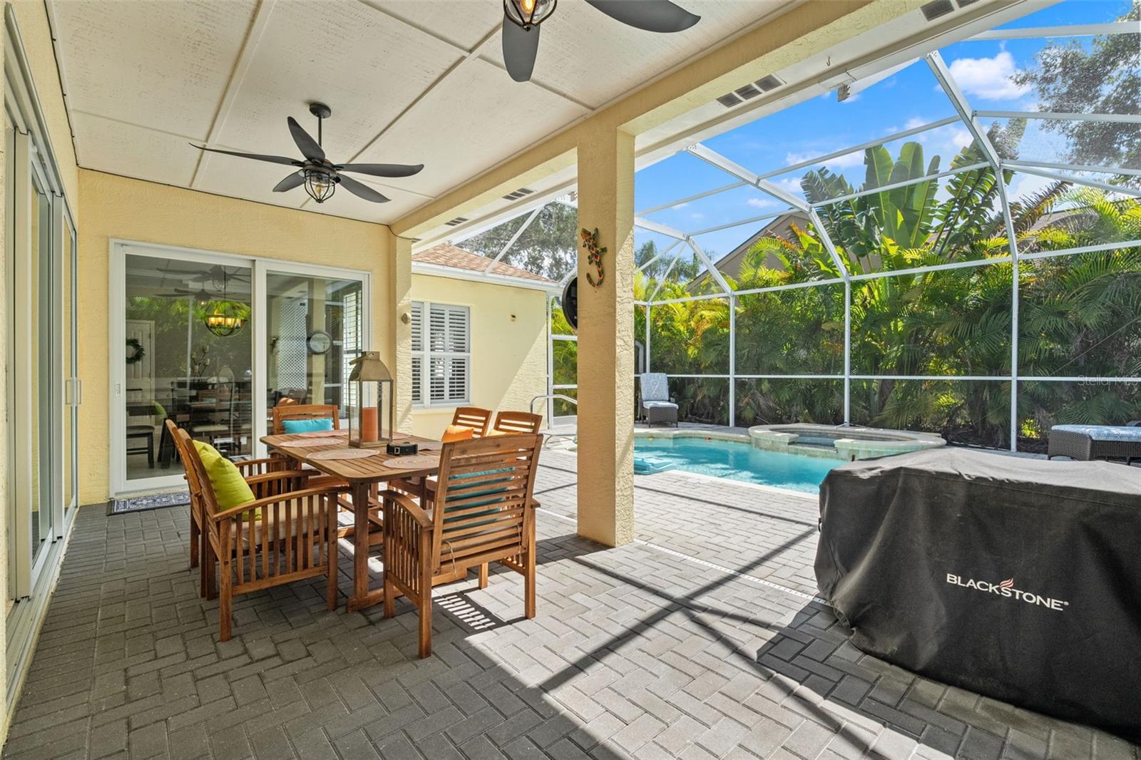Large sliding glass doors connect indoor living to this shaded retreat, ideal for seamless indoor-outdoor entertaining.