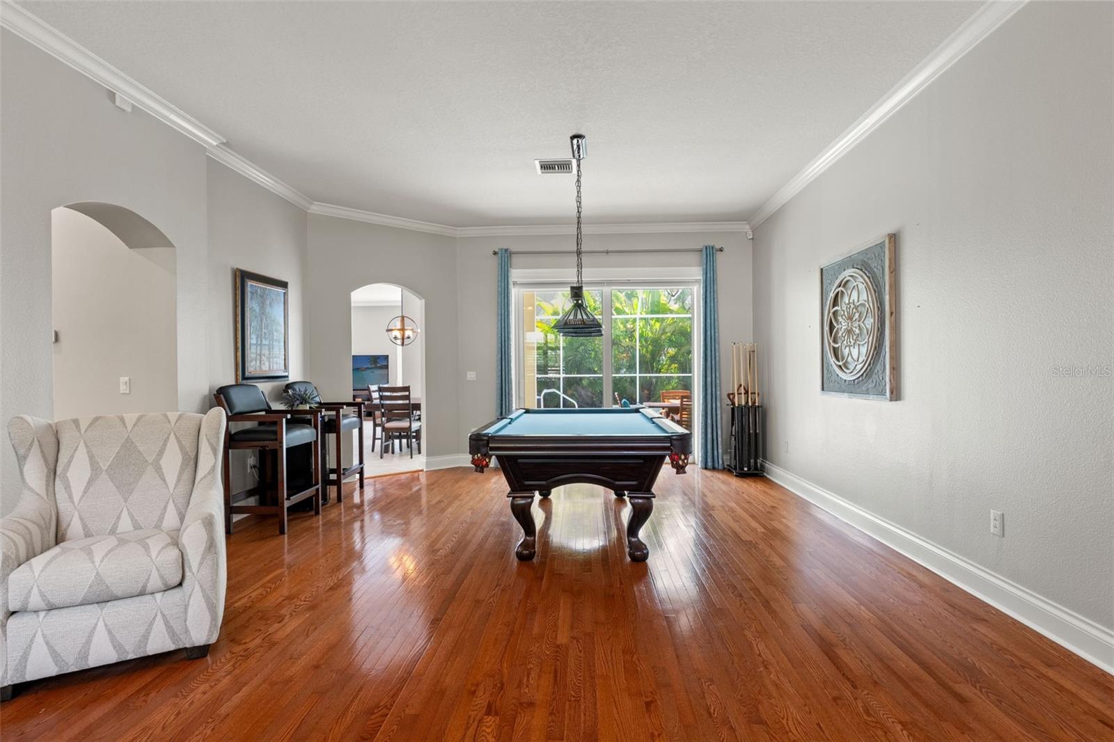 Centered around the pool table, this versatile area offers plenty of room for entertaining, with direct access to the adjoining dining space and natural light streaming in from pool views.