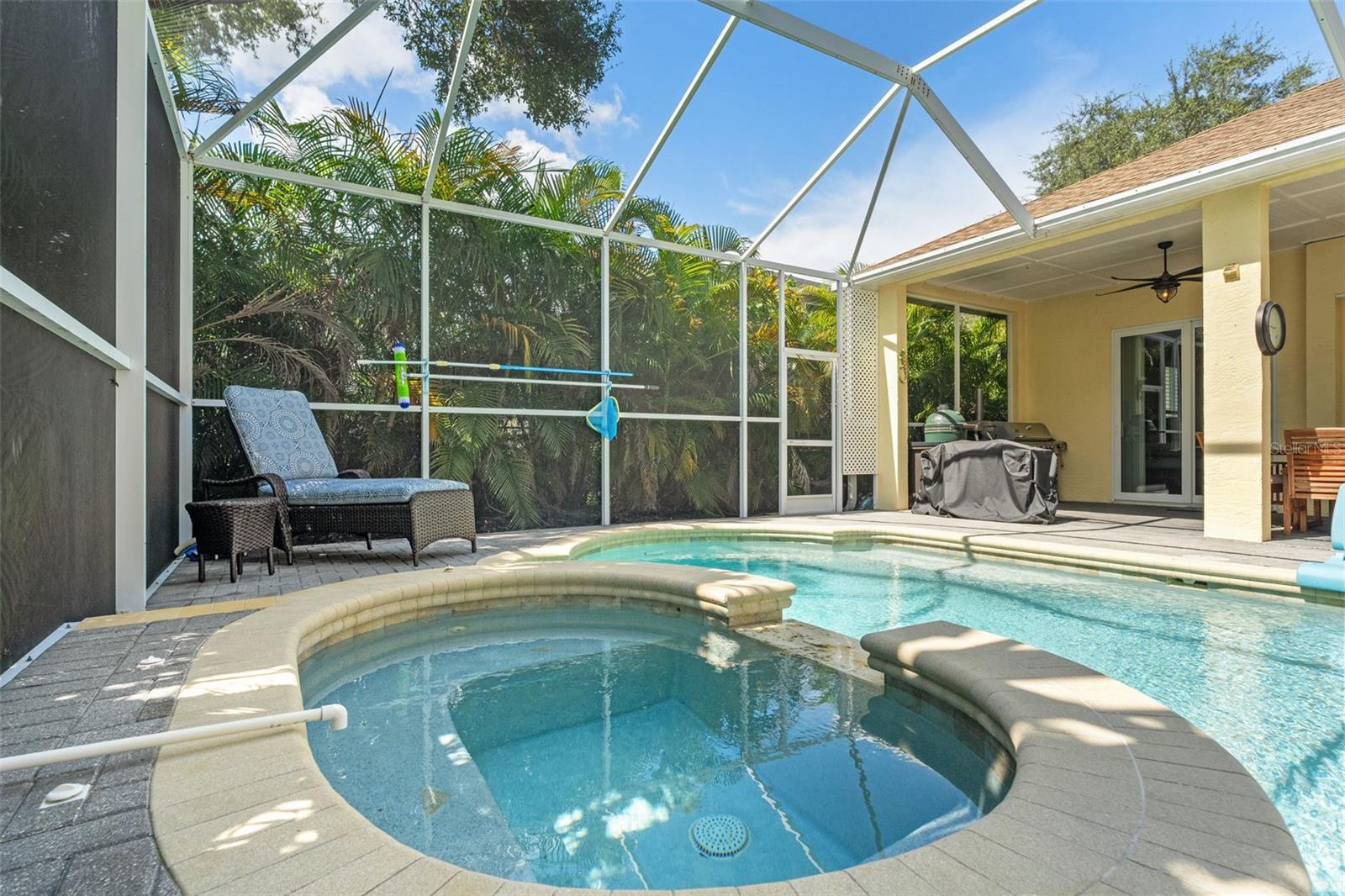 The raised spa overflows gently into the pool and features bench seating, creating a perfect spot to unwind after a long day.