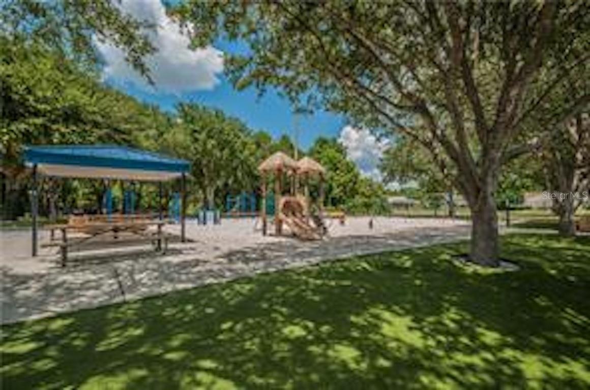 Shaded picnic tables and a modern playground provide the perfect spot for outdoor fun and family gatherings, surrounded by mature trees and green space.