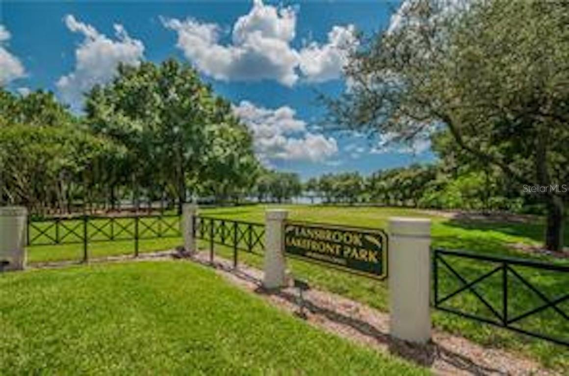 Well-manicured grounds and paved walkways wind along the shoreline, offering benches, scenic views, and room to relax beneath the trees.