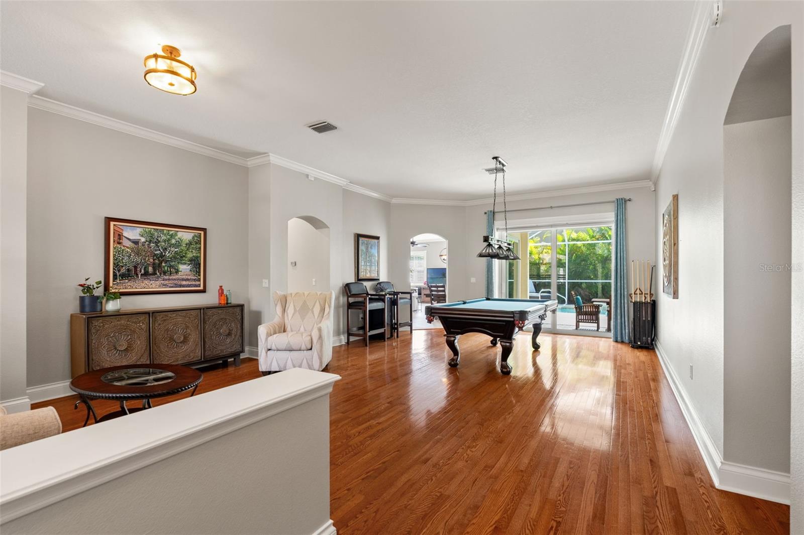 A seamless blend of relaxation and entertainment, this open concept space includes a comfortable seating area, a formal dining room, and easy access to the screened lanai/pool for indoor-outdoor living.