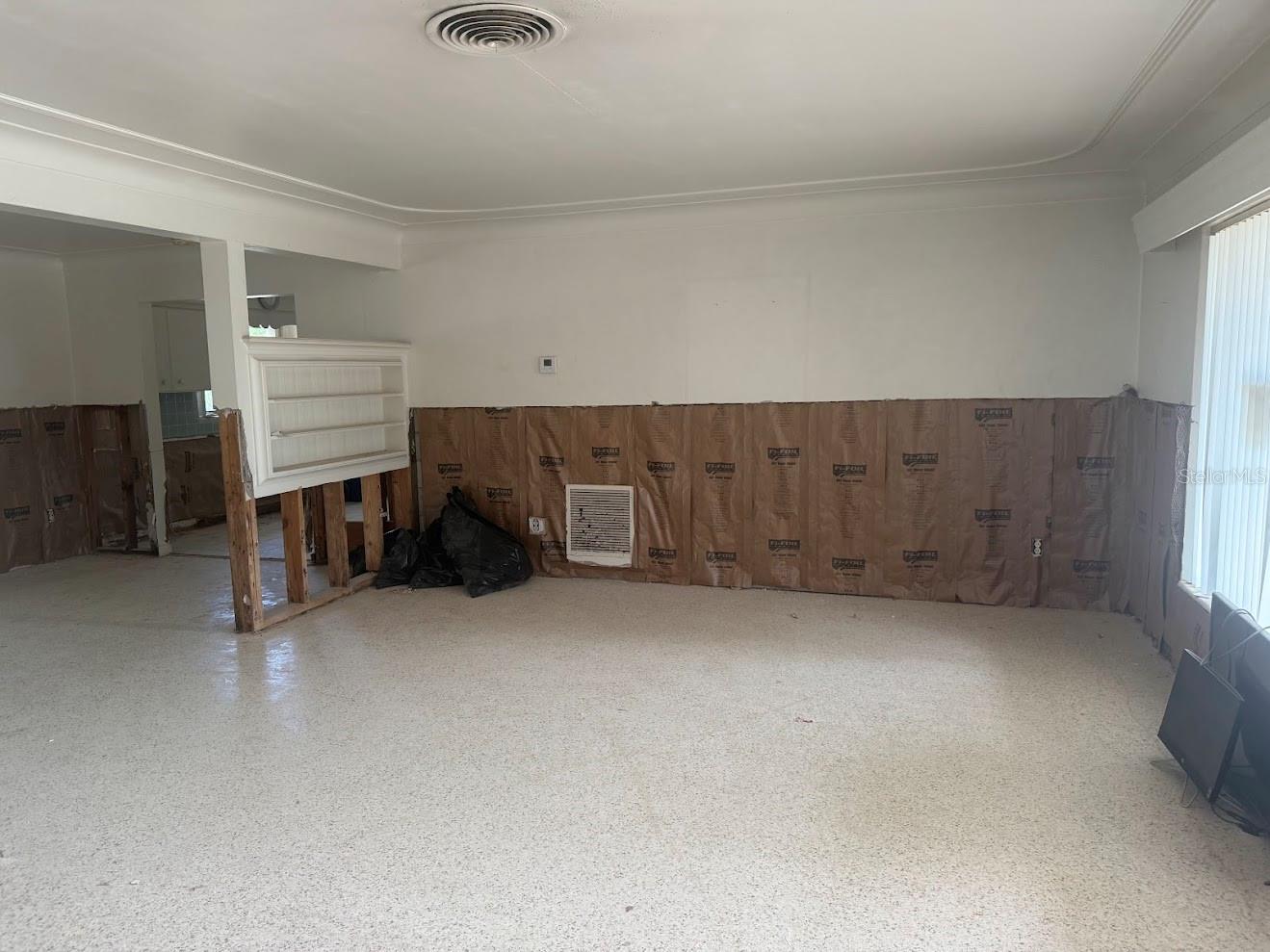 Beautiful terrazzo floors await polishing, and the spacious living room is filled with abundant natural light.