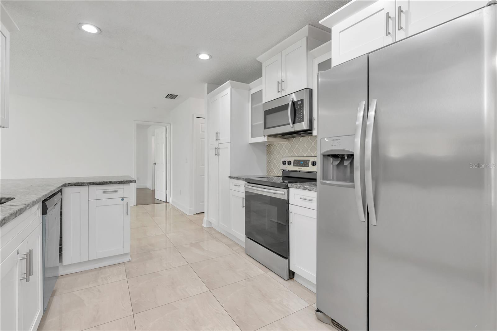 Beautiful kitchen featuring sleek appliances—all covered by an American Home Warranty for added peace of mind.