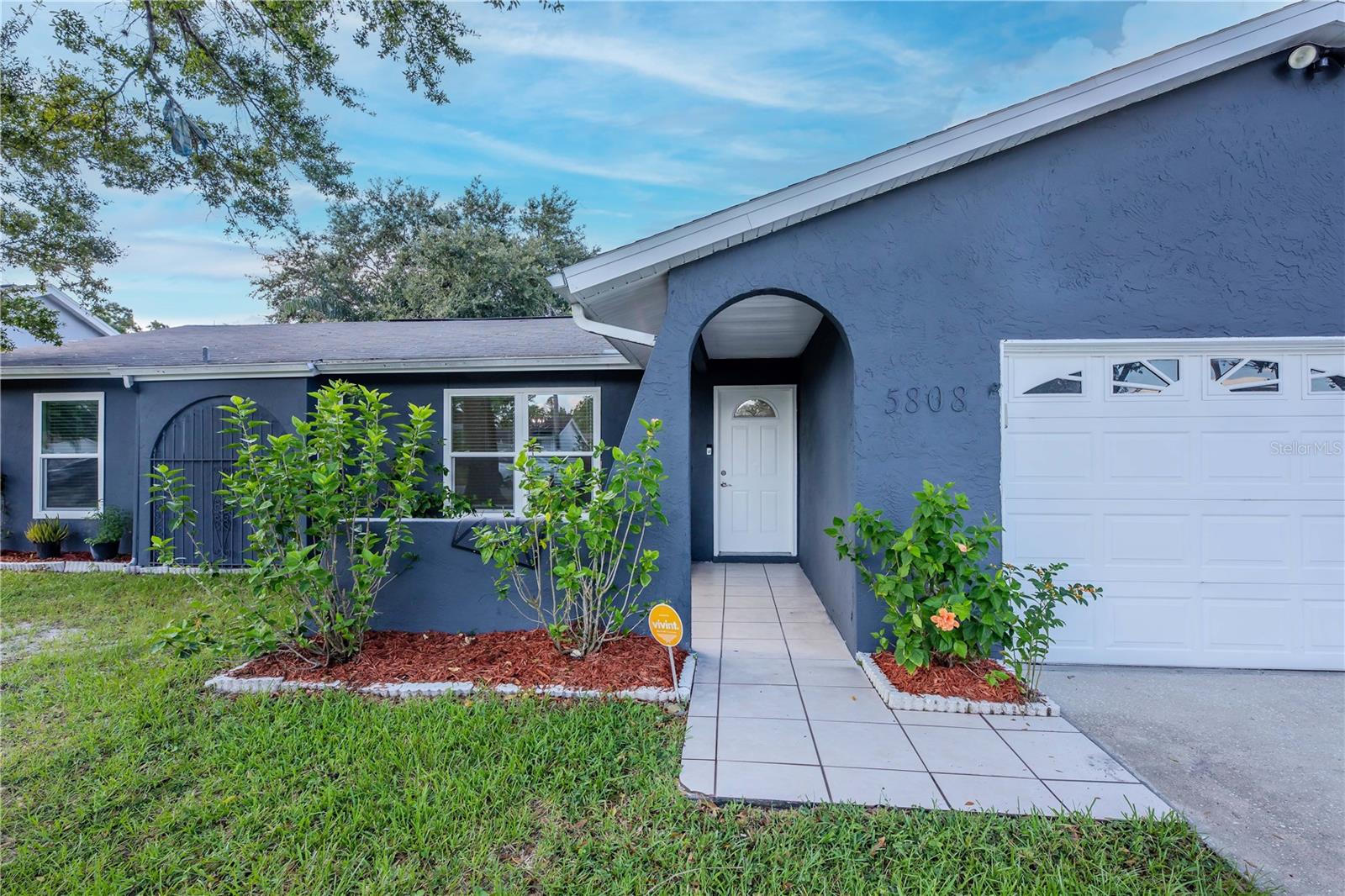 Set in a desirable community, this home shines with its updated exterior, tree-lined front yard, and spacious driveway surrounded by greenery.