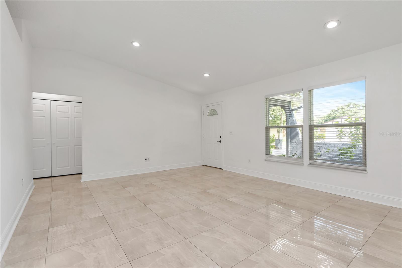 Stylish tile flooring enhances the room’s elegance, while large windows provide plenty of natural light and a peaceful view outside.