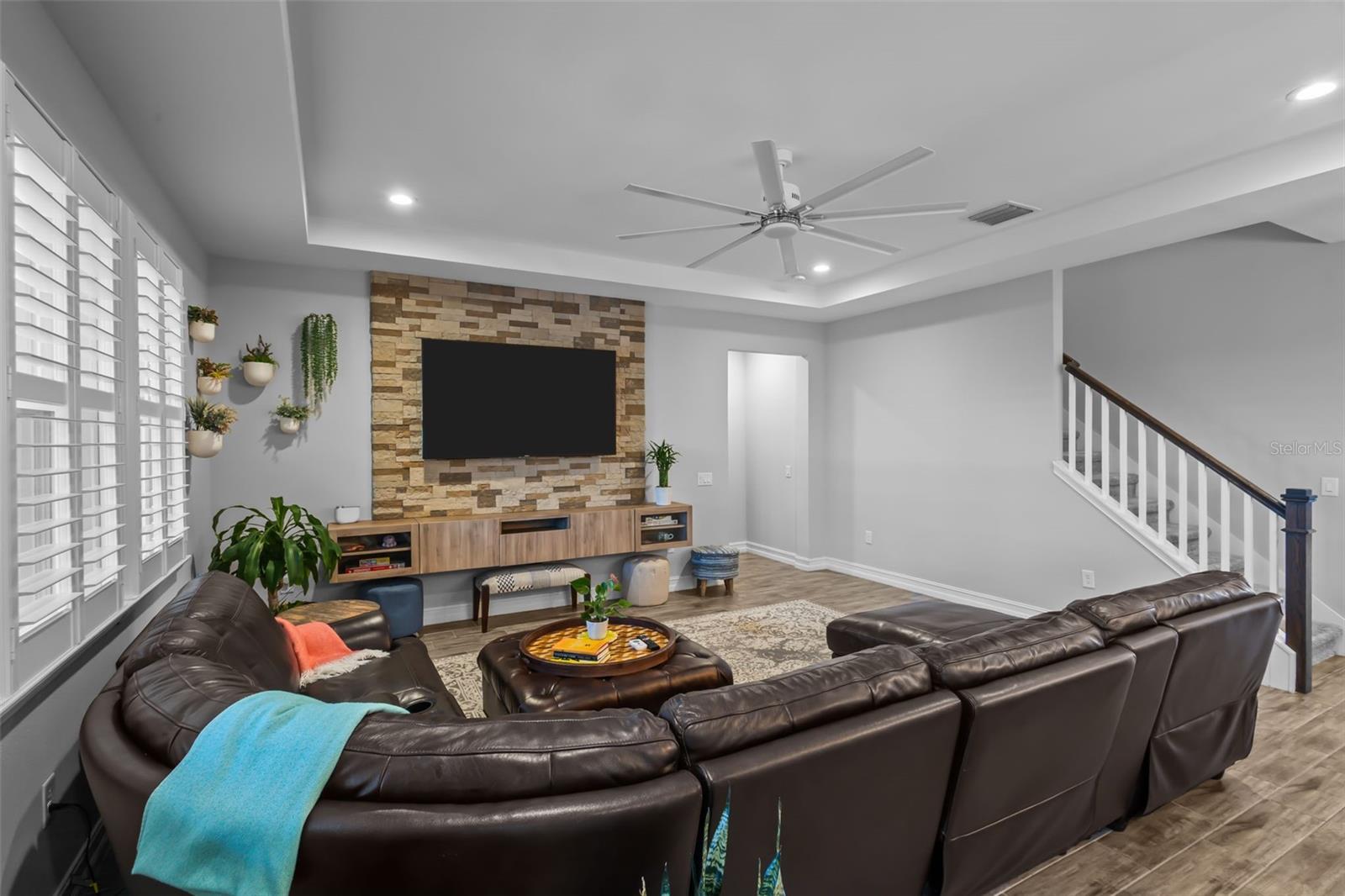 Living room has a stone feature wall, doorway to right takes you to the primary suite