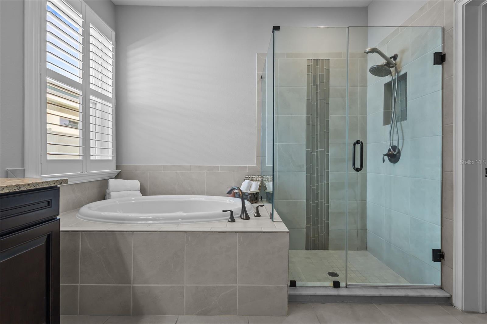 Primary Bathroom has framelss shower and garden tub