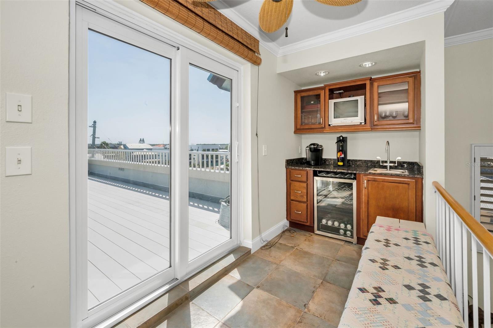 .. Shot of Sliders Opening to Roof Top Patio. 5' x 3' Wet Bar in Corner - Perfectly Placed For Entertaining Purposes. Owners Say It Comes in Extremely Handy..  Sliders have Storm Shutters for Closing Condo Down if You are Leaving Town for awhile.