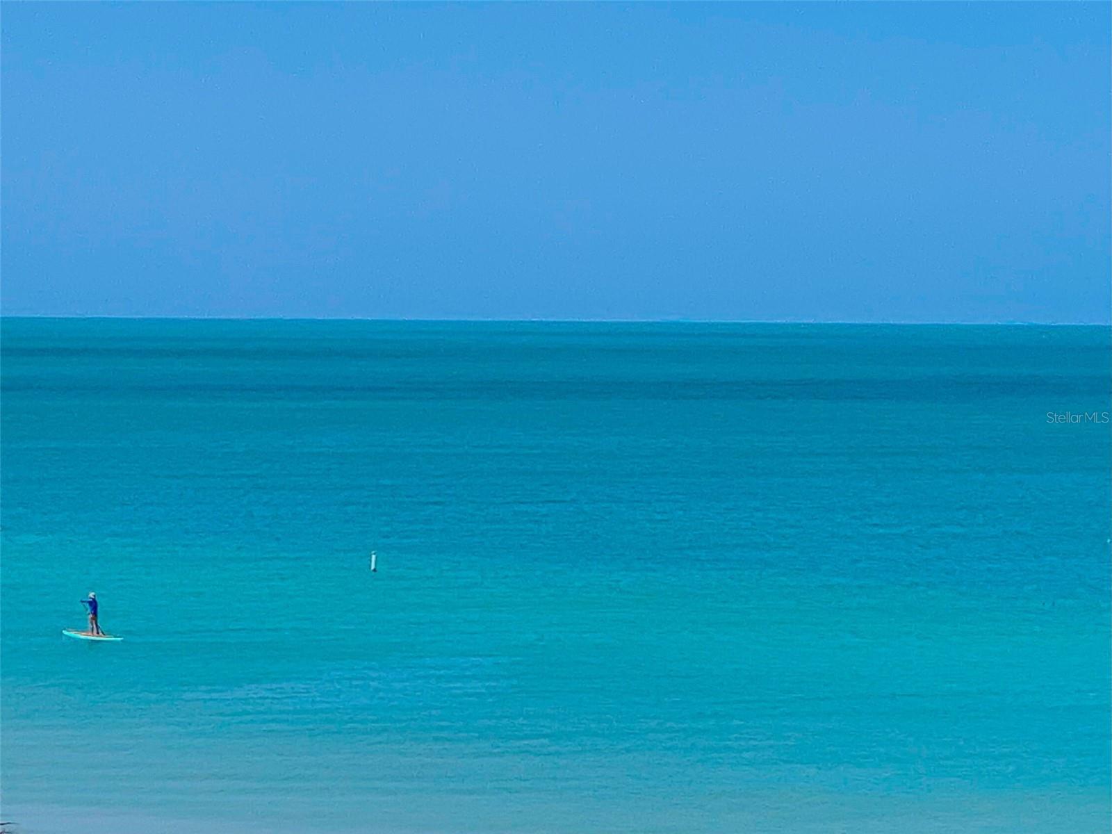 .. Shot taken From Roof Top Patio Towards Beach. Someone Getting in an Early Morning Paddle Board Work Out.