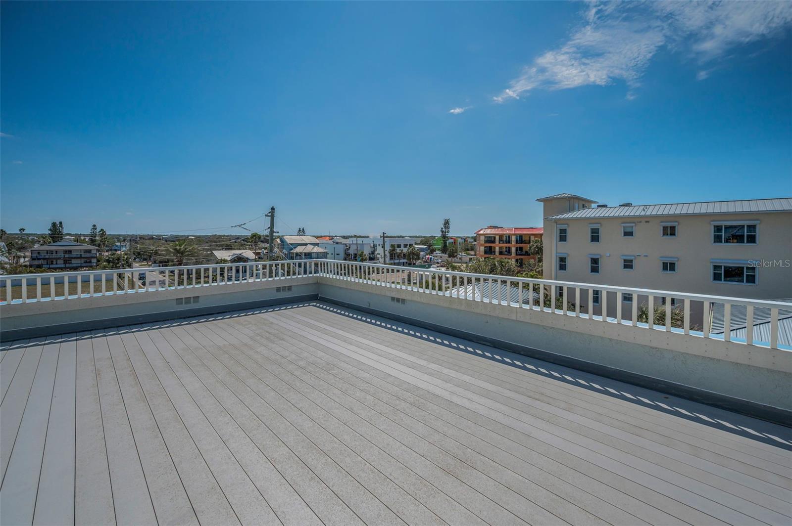 .. 22 x 25 Roof Top Deck. Sellers Love to Entertain Up Here. View Looking East. A Parapet Wall is a Short WAll Projecting Up From The Outer Edges of A Structure. Here The Top Part of The Parapet Wall is Slotted to Allow an Open View Whle Seated..