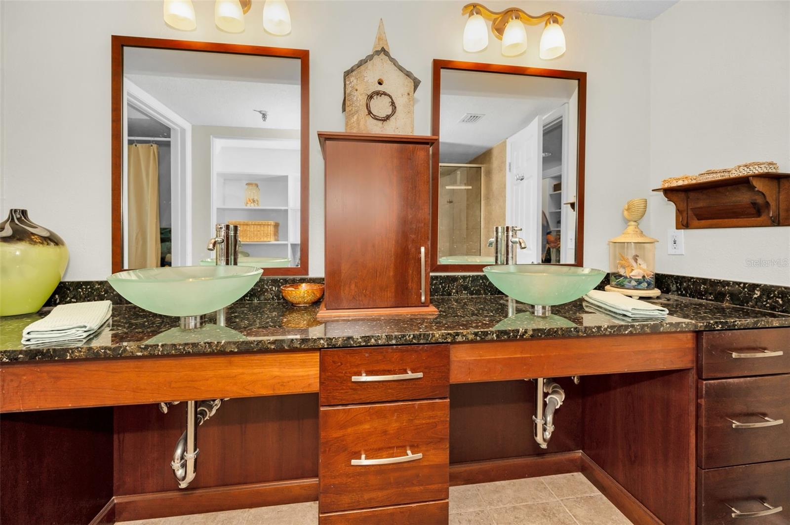 ..His & Hers Seagrass Vessel Basins Compliment the Rich Wood Color . Master Bath