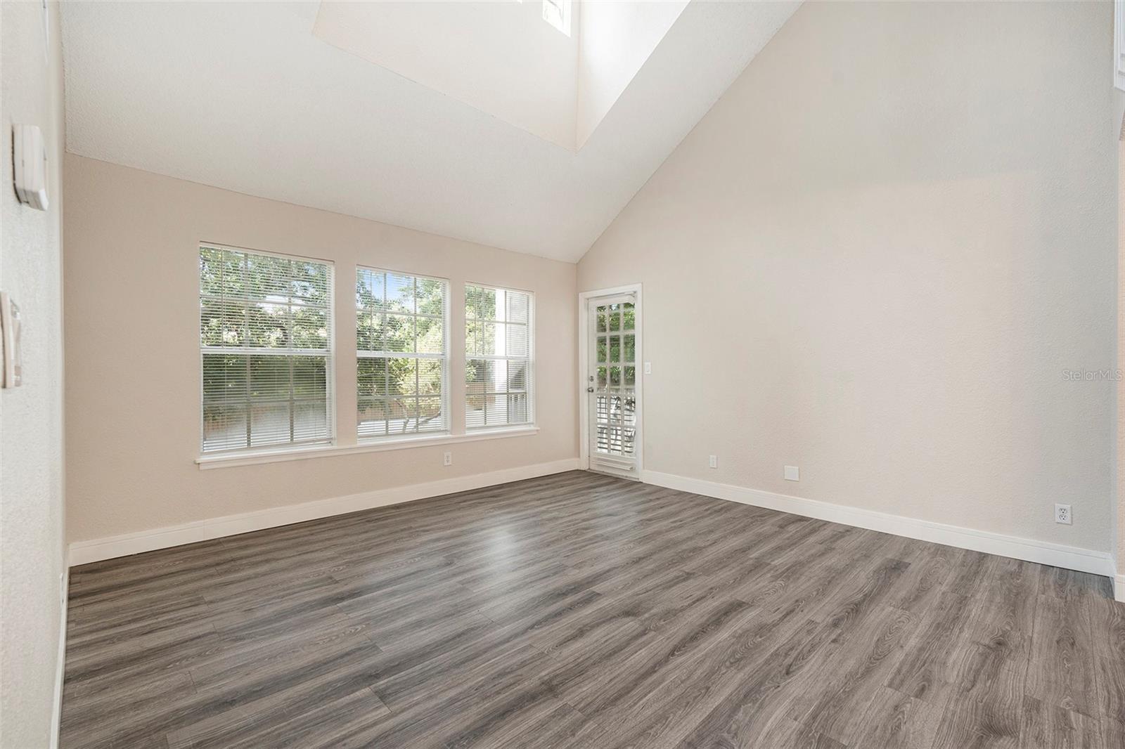 Large, bright living room, high ceiling, access to balcony