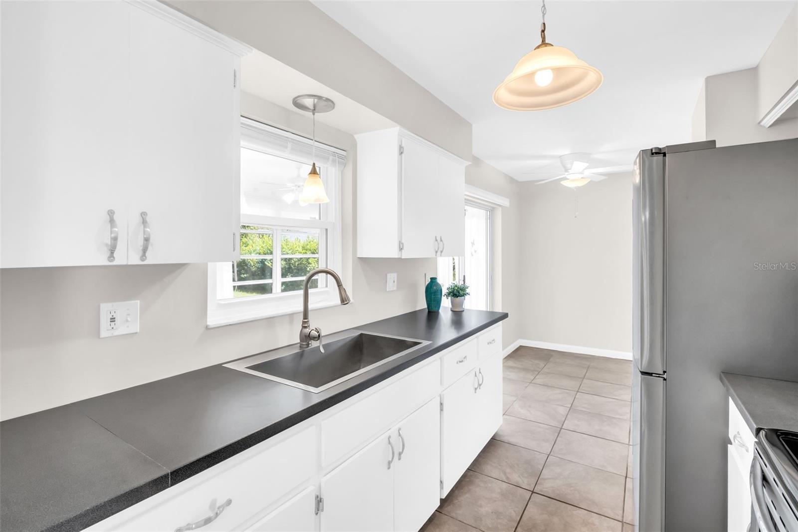 Beautiful kitchen updates, new deep sink, and pass- through window to enclosed lanai for easy entertaining~