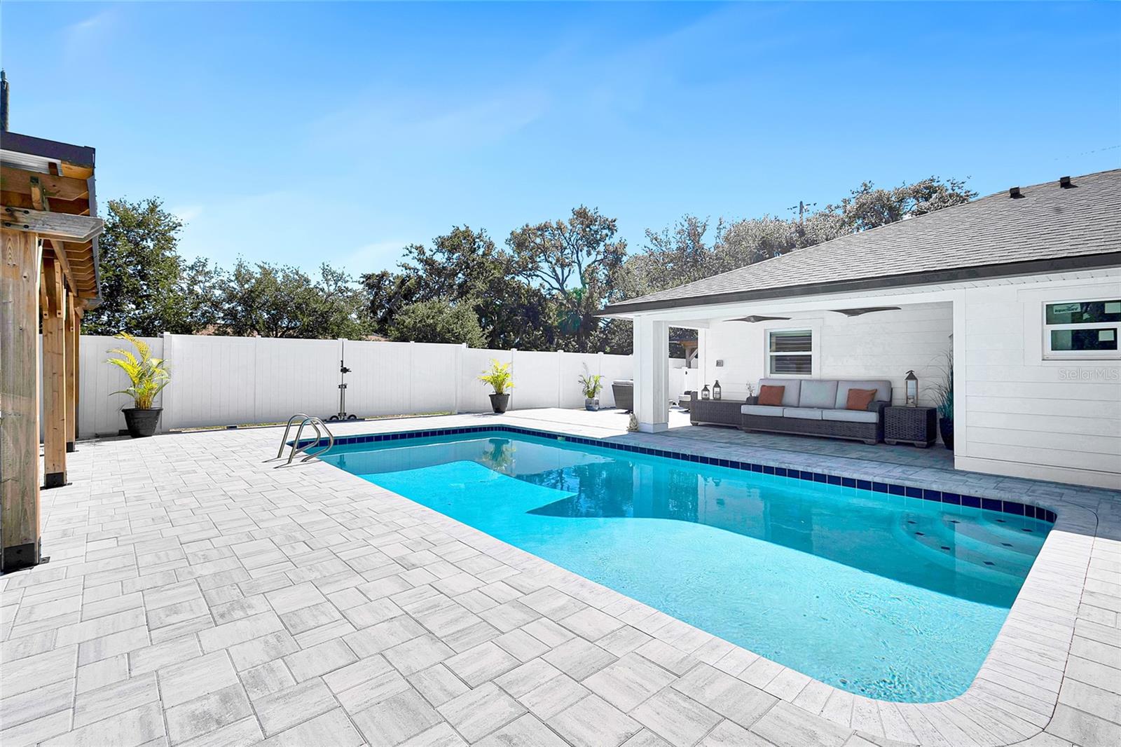 Pool with covered patio area, near outdoor kitchen
