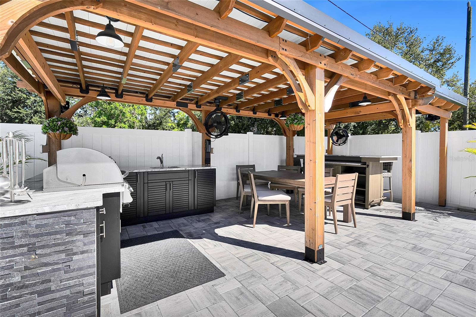 Outdoor kitchen, dining and bar under covered pergola