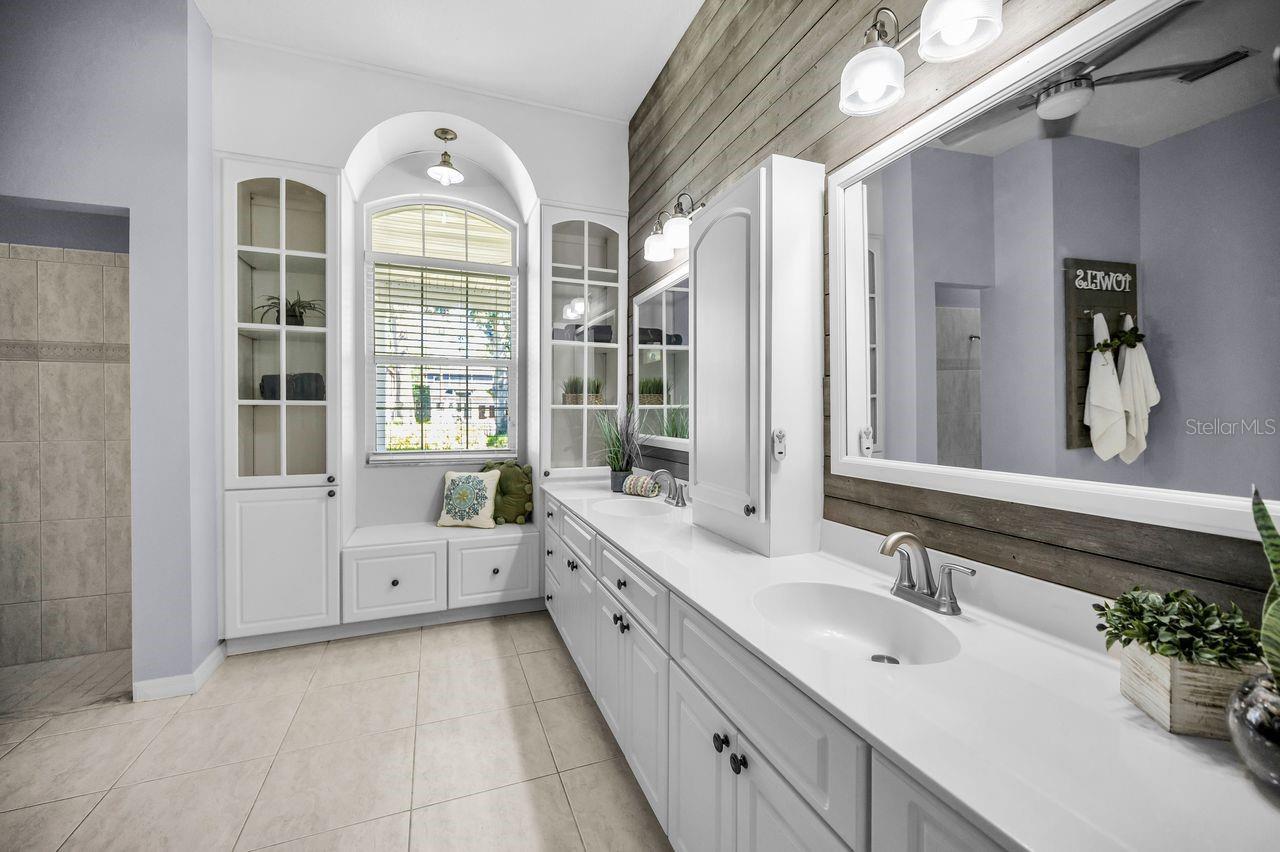 Just look at this stunning custom primary bath! Double sinks, a window seat, plenty of storage, and so much more!