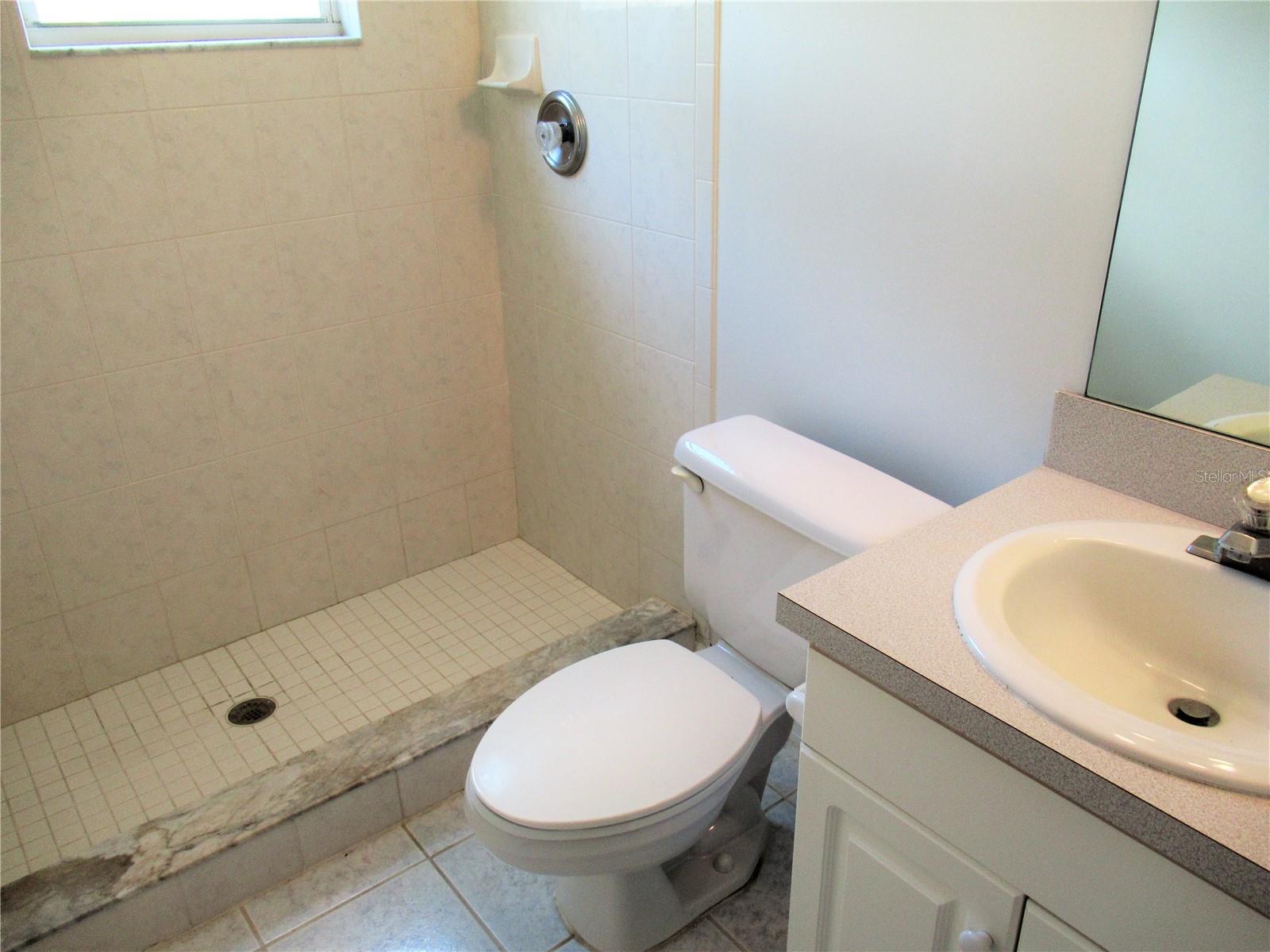 En-suite bathroom to first level bedroom with step-in shower