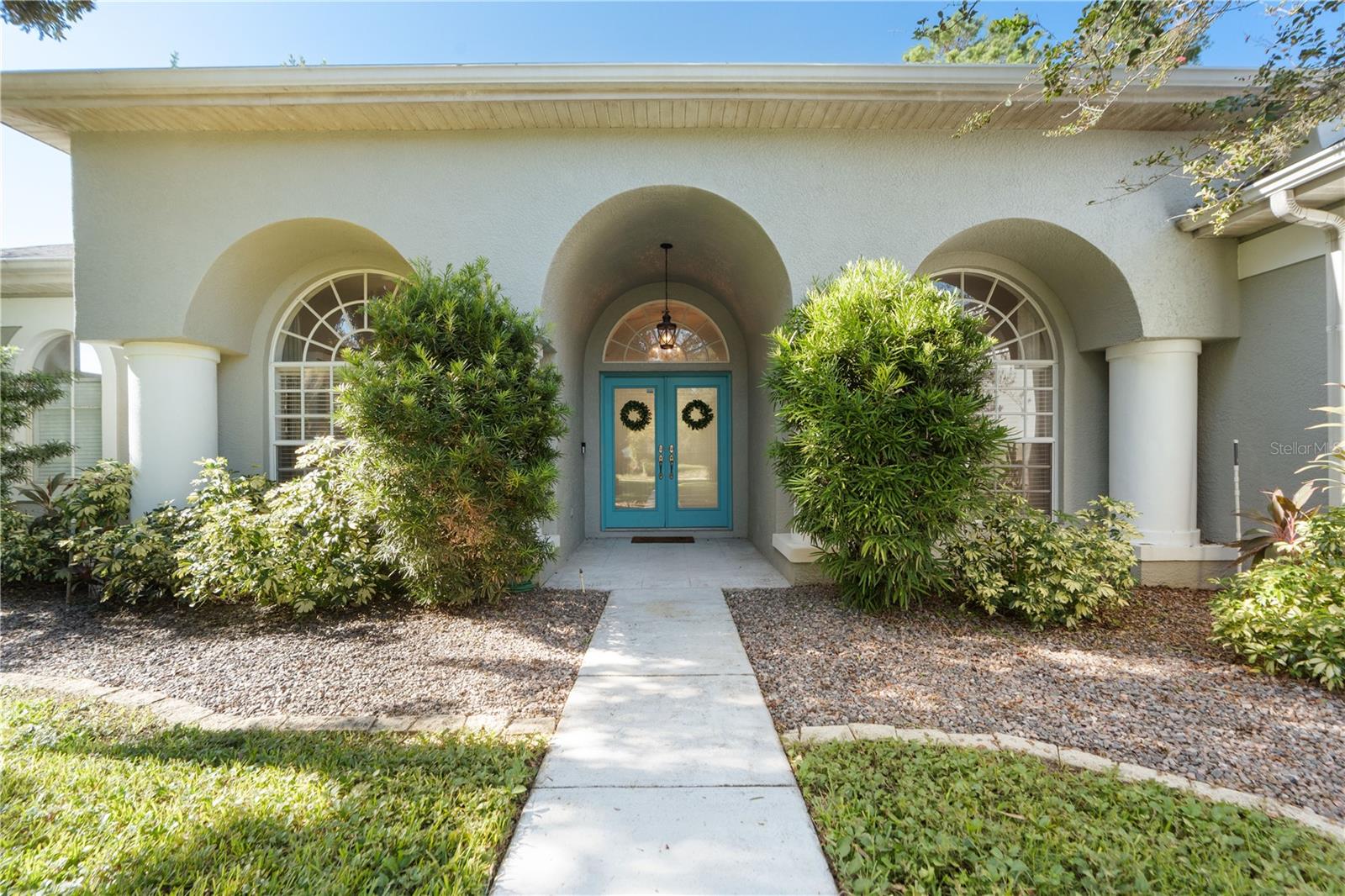 French double doors at entry way, three archers, large windows and scallop shaped transoms bring in the NATURAL light. The front of the house faces North.