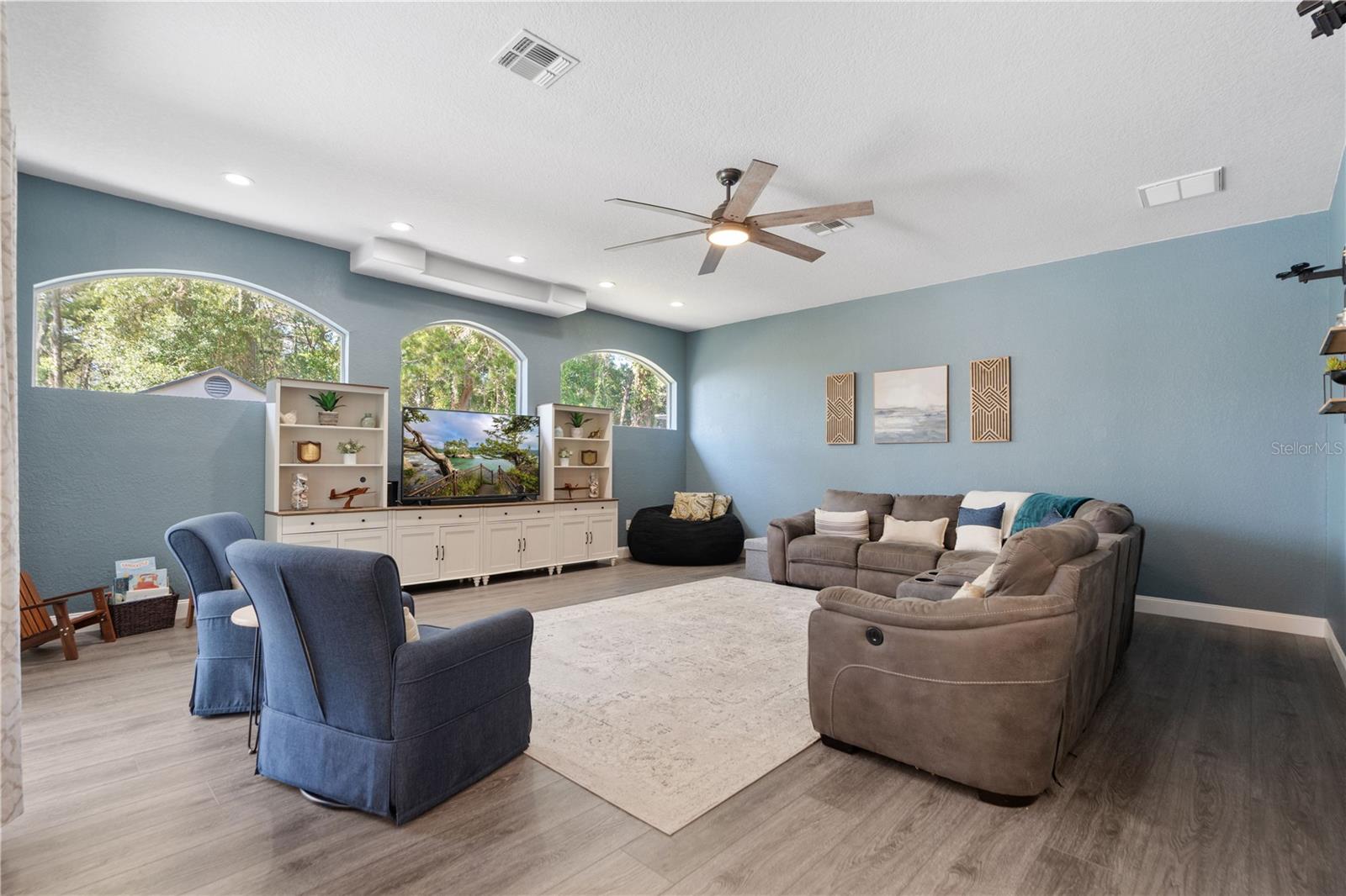 Luxury Vinyl flooring follows through most of the home including the large livi8ng room with recessed lighting.