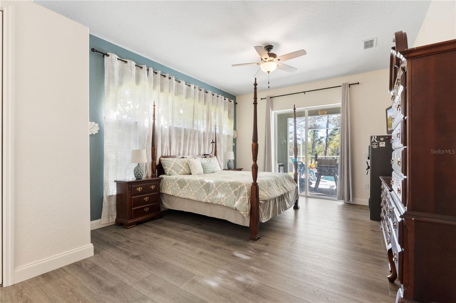 Sliding glass doors lead from the primary bedroom to the lanai and pool