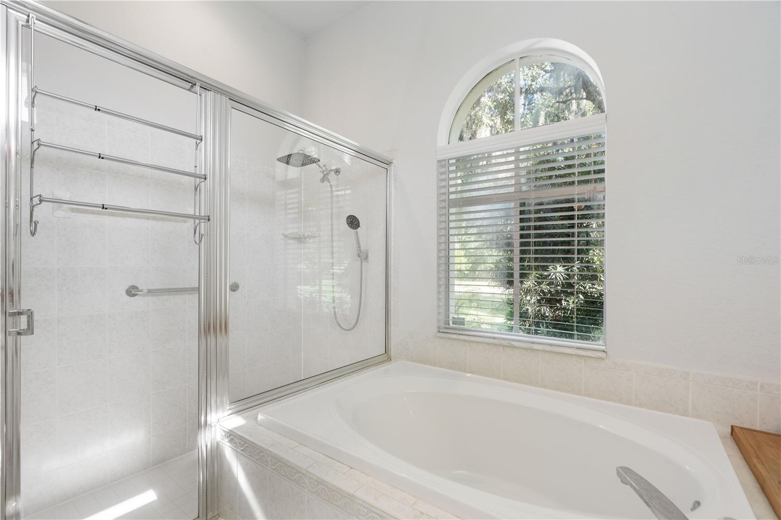 Primary bathroom is bright with a window for ventilation, a soaking tub and a separate stand up shower.