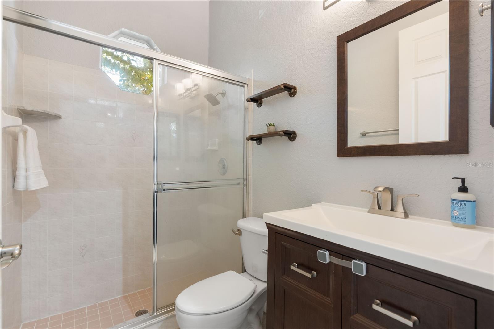 This full bathroo with shower has a window that brings natural light into the shower.