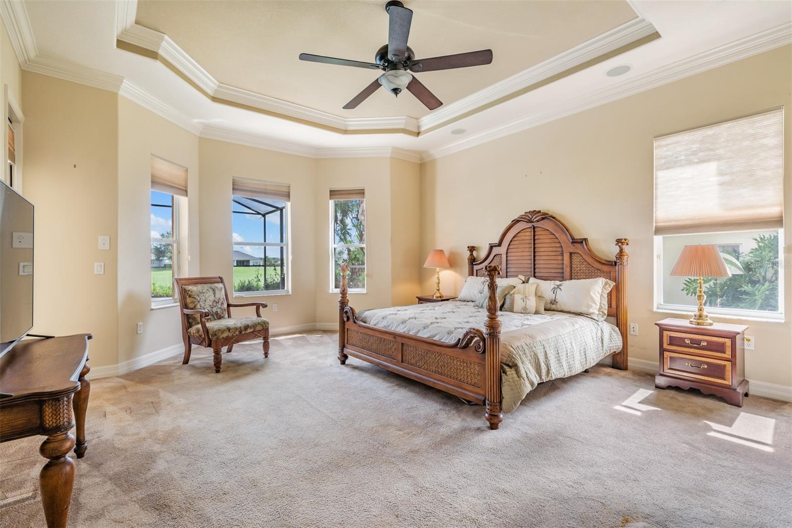 Grand primary bedroom with sitting area overlooking pool