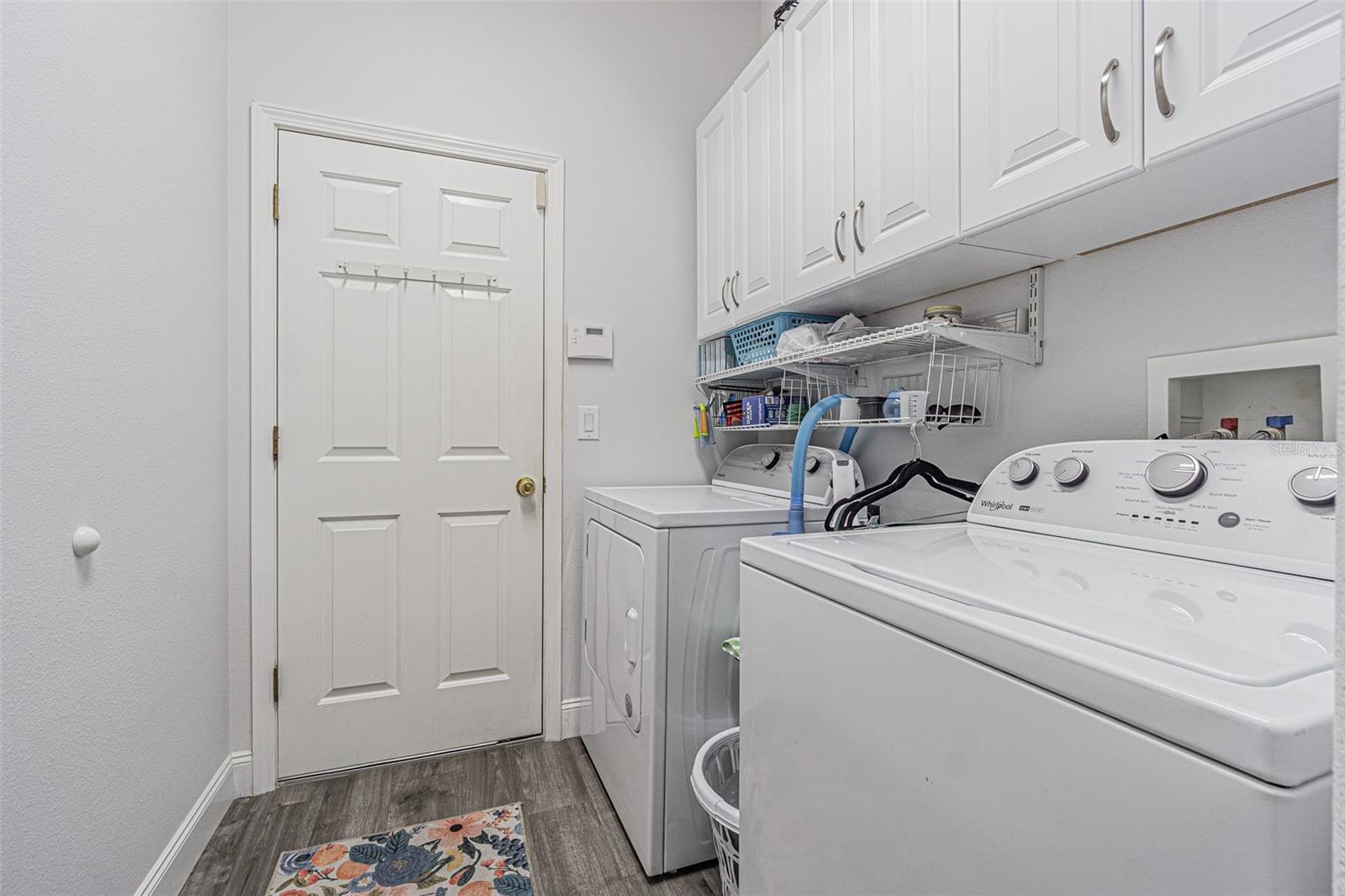 Interior laundry room with storage above