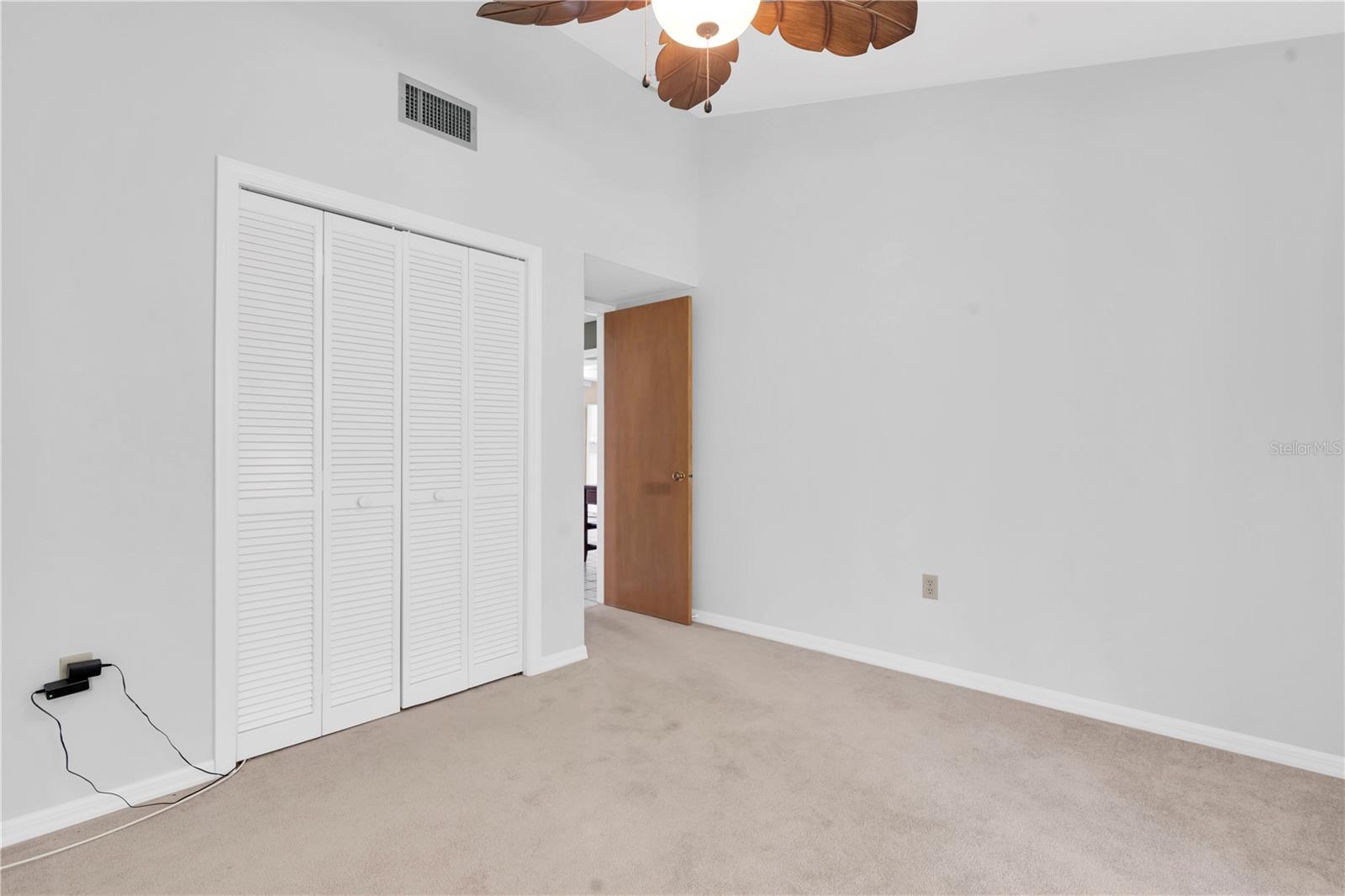 2ND BEDROOM...HARD TO TELL THAT IT'S A GOOD SIZE IN THIS SHOT; WIDE AND DEEP CLOSET; NOT SHOWN ARE THE DOUBLE SLIDERS THAT GO DIRECTLY OUT TO THE BACK SCREEN LANAI; CEILING FAN AND LIGHT  (1377 MCMULLEN BOOTH RD)