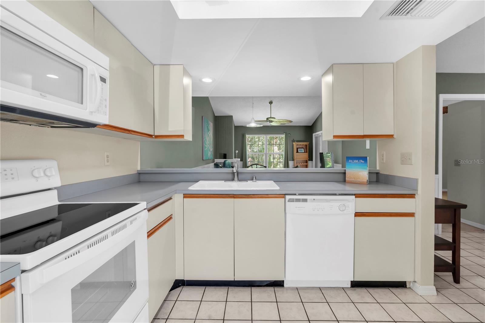 KITCHEN WITH VIEW OVER BREAKFAST BAR INTO DINING/LIVING ROOM; TRAY CEILING WITH CEILING FAN AND LIGHT  (1377 MCMULLEN BOOTH RD)