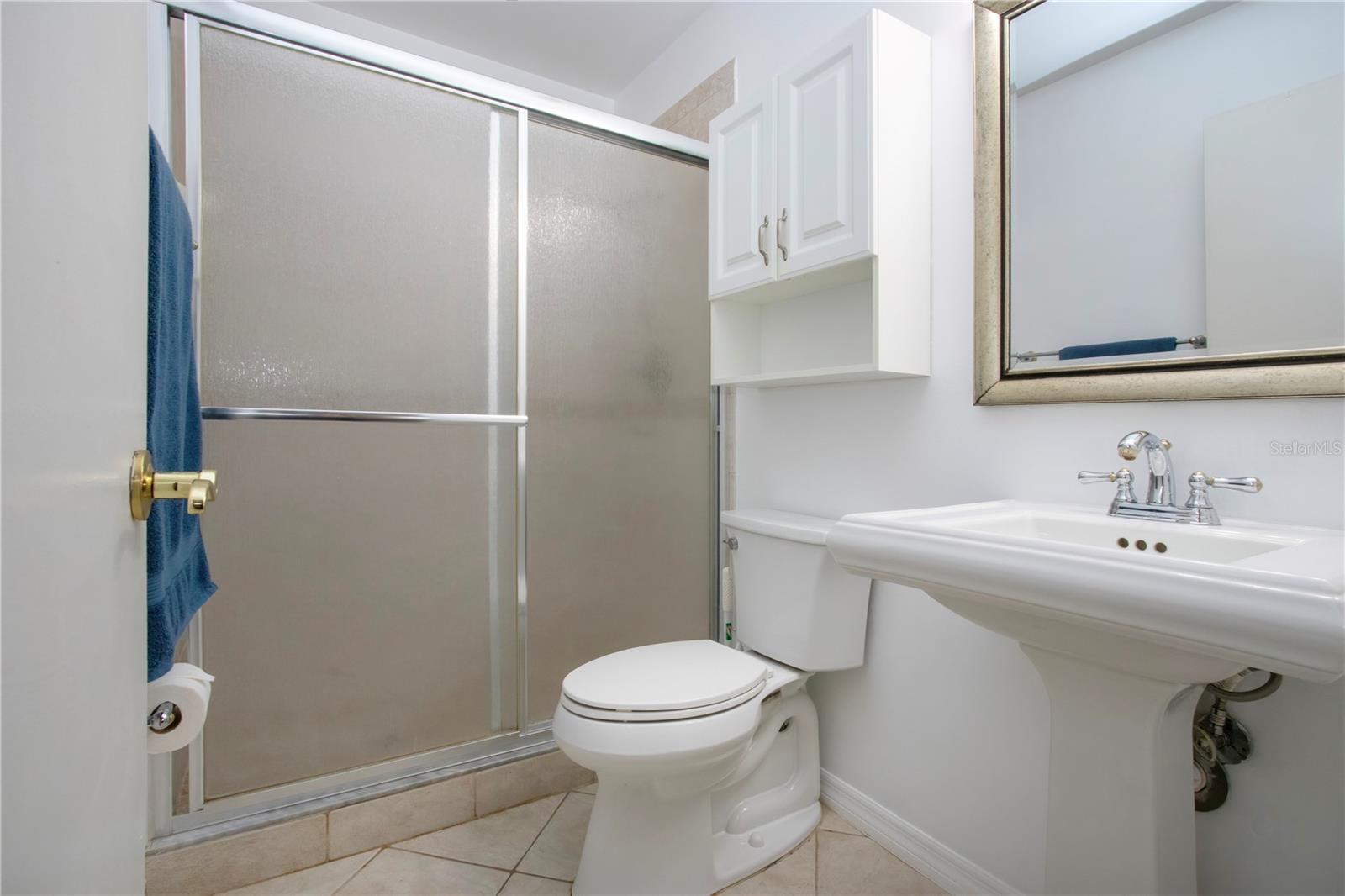 Primary bathroom with pedestal sink and updated shower