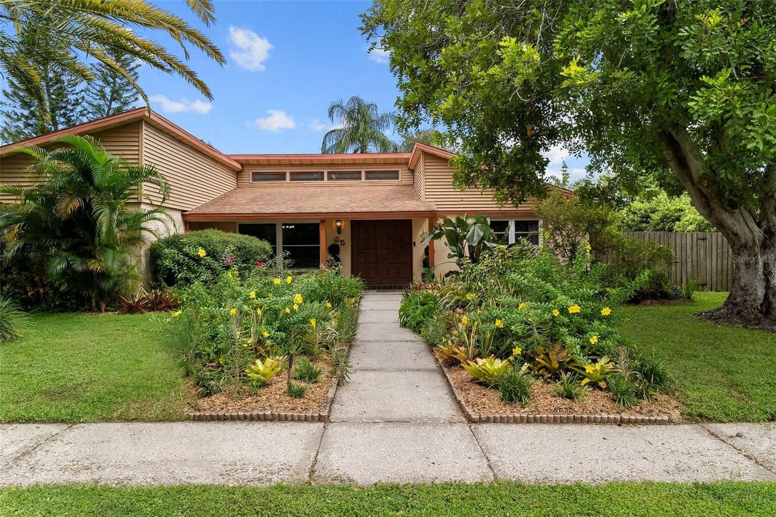 Safety Harbor gem! Beautifully maintained pool home on a spacious corner lot with mature landscaping and inviting curb appeal.
