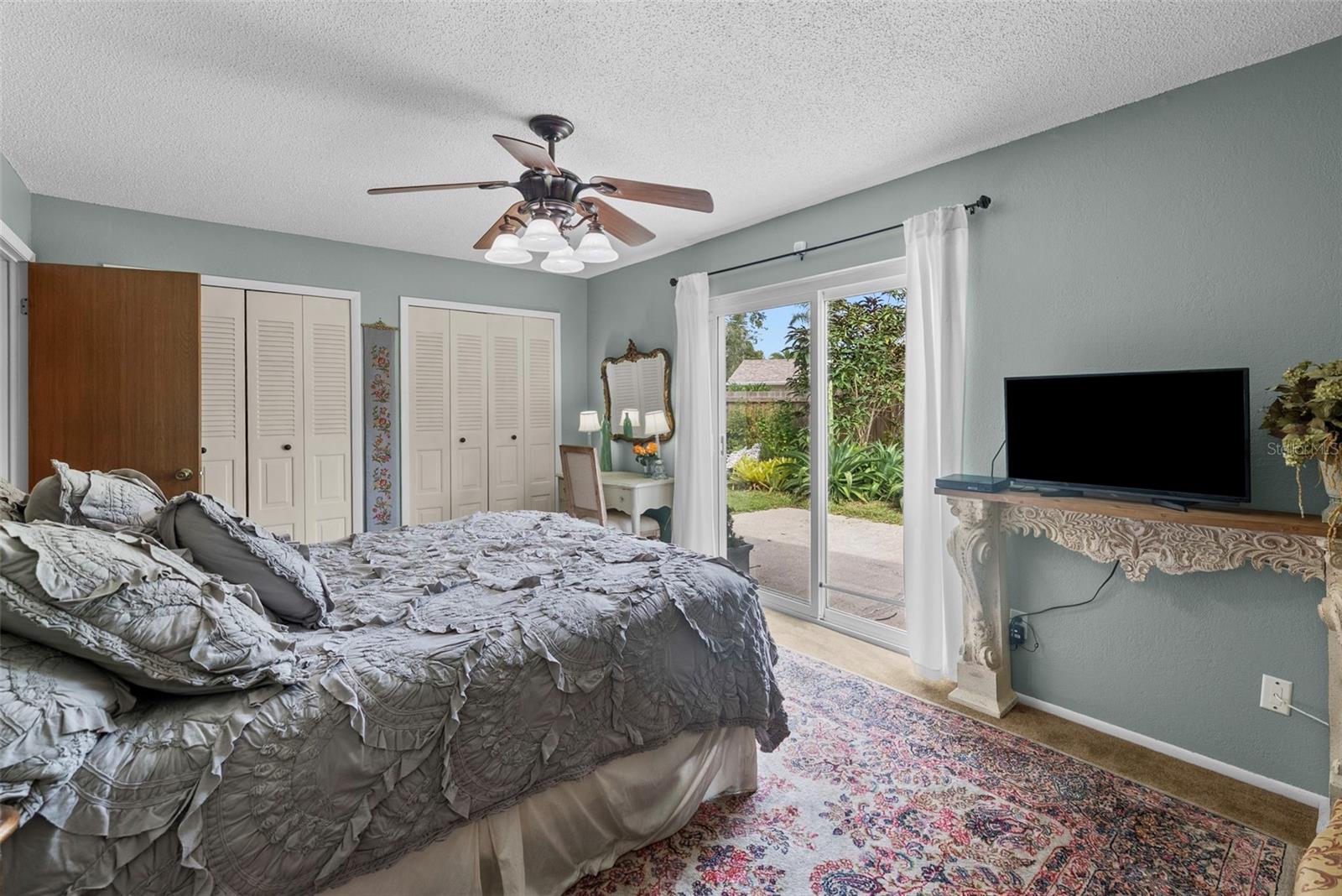 Spacious master suite with sliders opening directly to the pool and backyard retreat.
