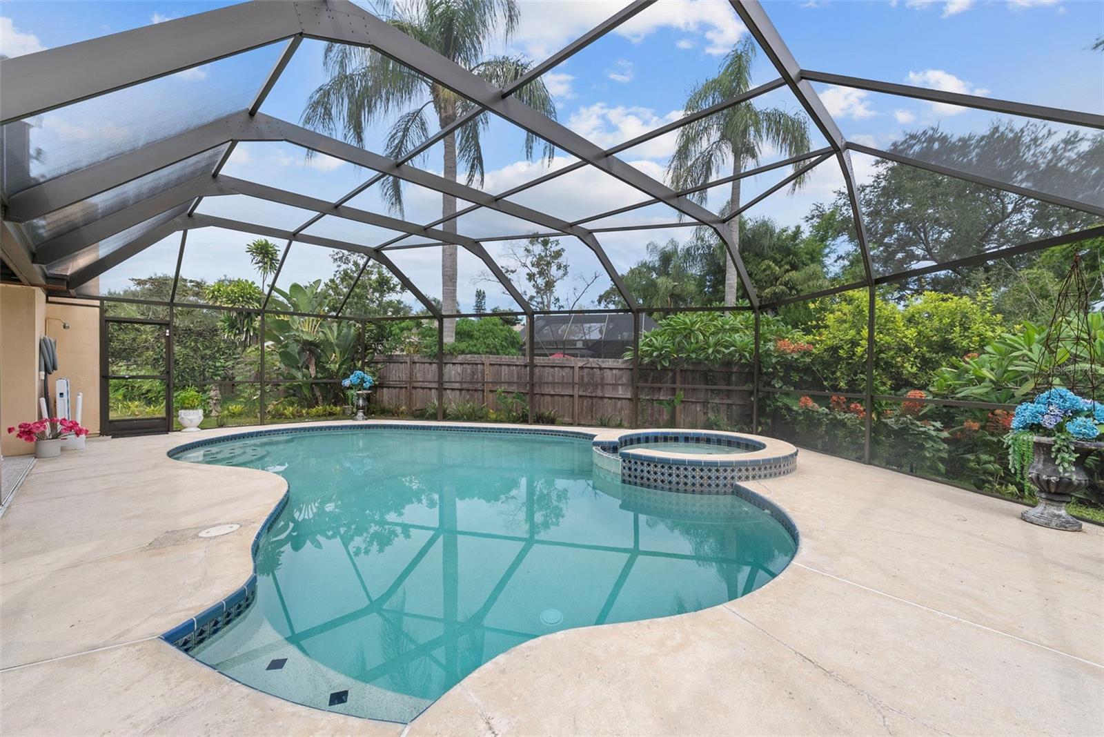 Private retreat featuring resurfaced saltwater pool (2024), propane-heated spa, and rescreened cage with freshly painted frame (2025).