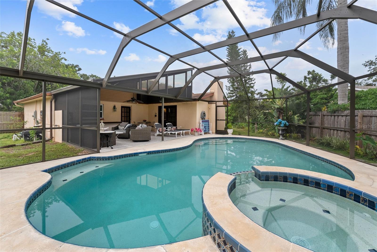 Private retreat featuring resurfaced saltwater pool (2024), propane-heated spa, and rescreened cage with freshly painted frame (2025).