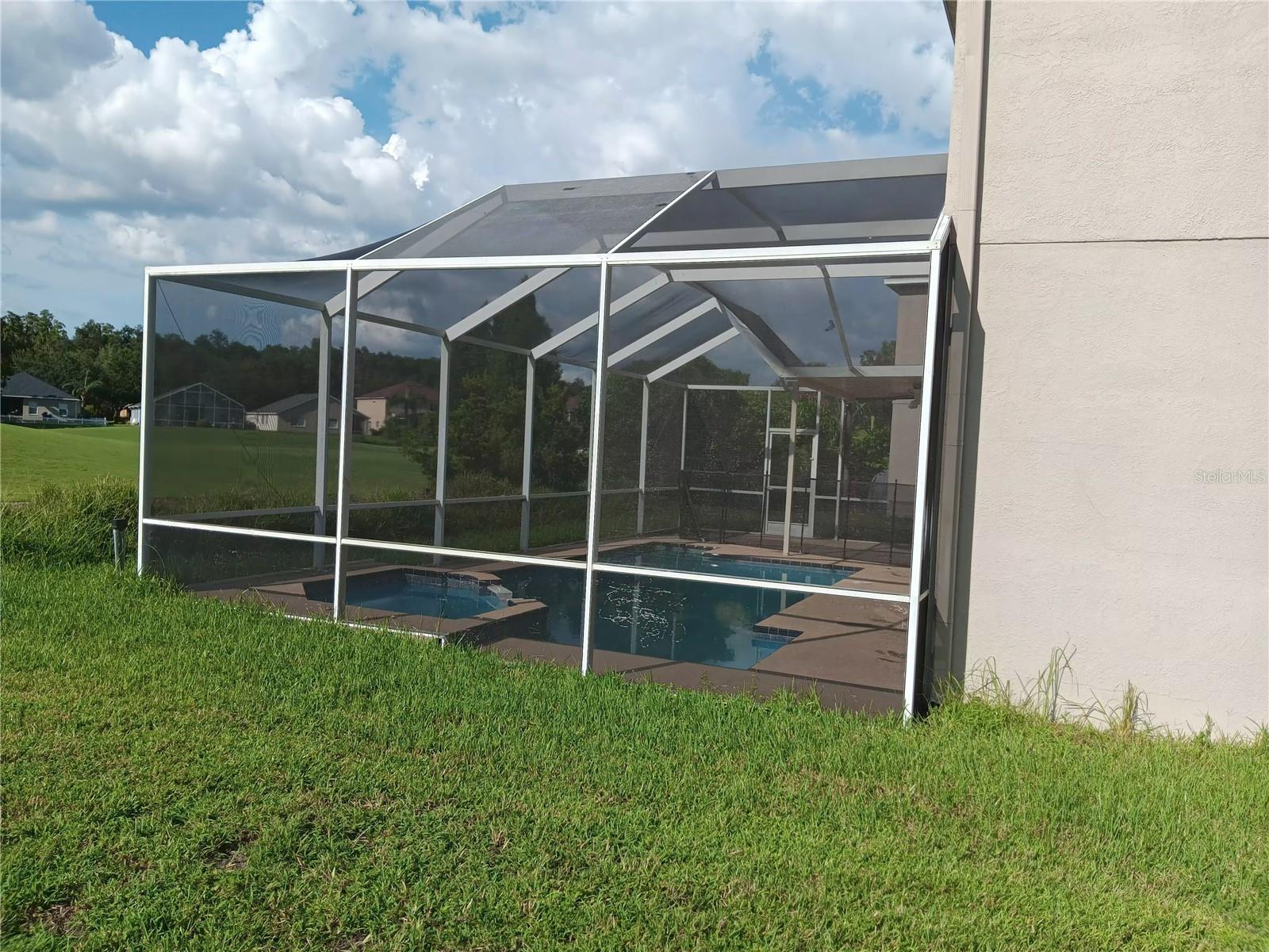 screened pool with spa on golf course