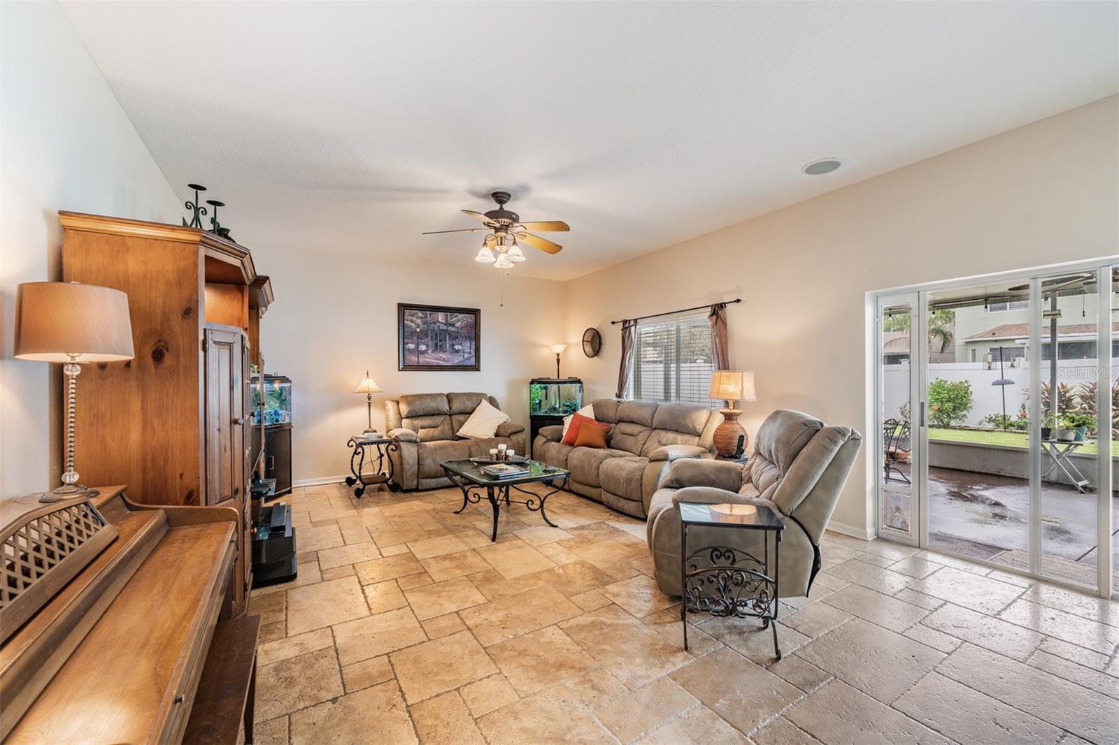 Family Room with ceiling fan/light fixture, with sliding glass doors to the lanai.