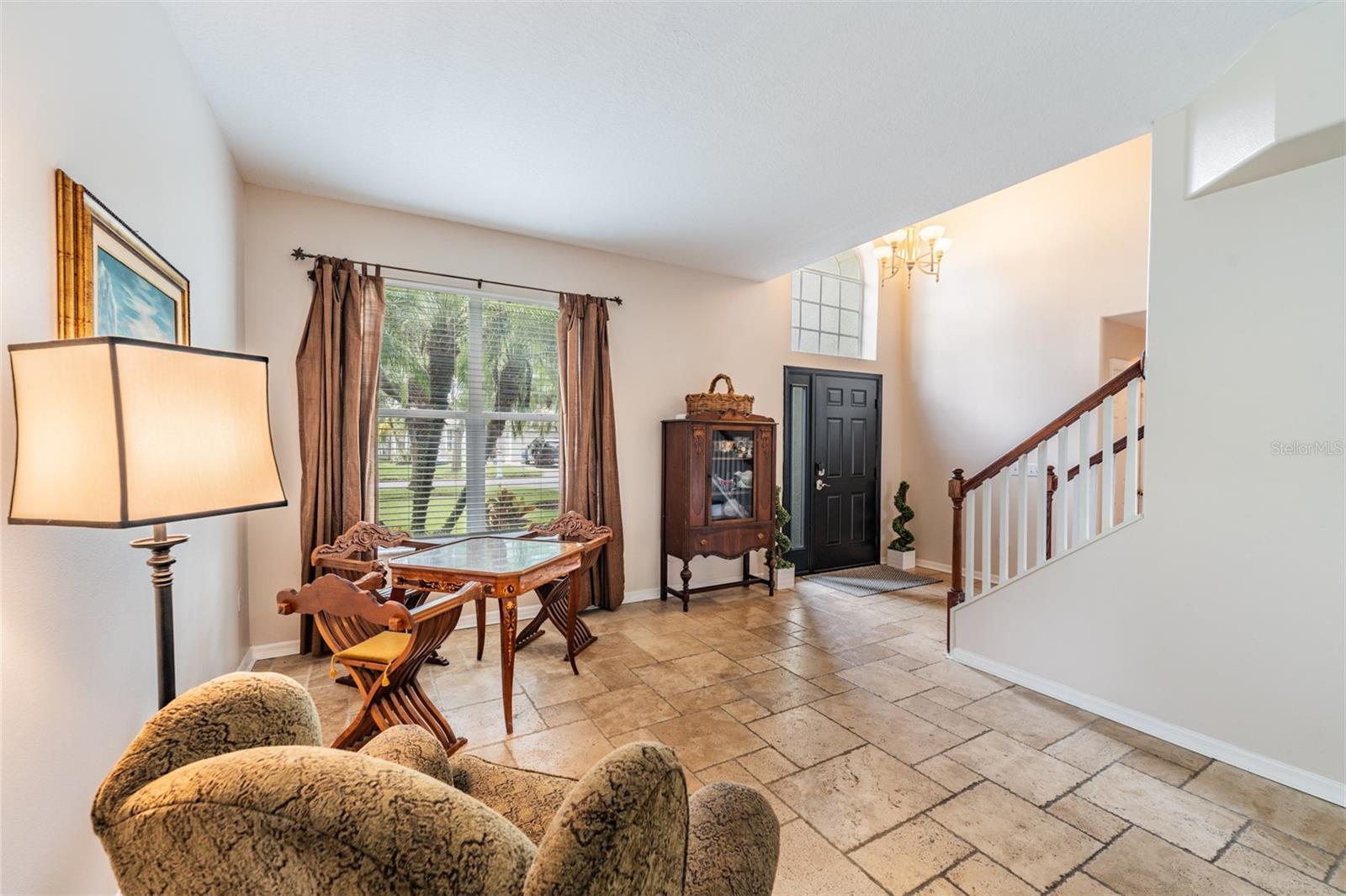 Living Room with Tile Flooring, lots of sunlight coming in the Front window and above the Front Door.