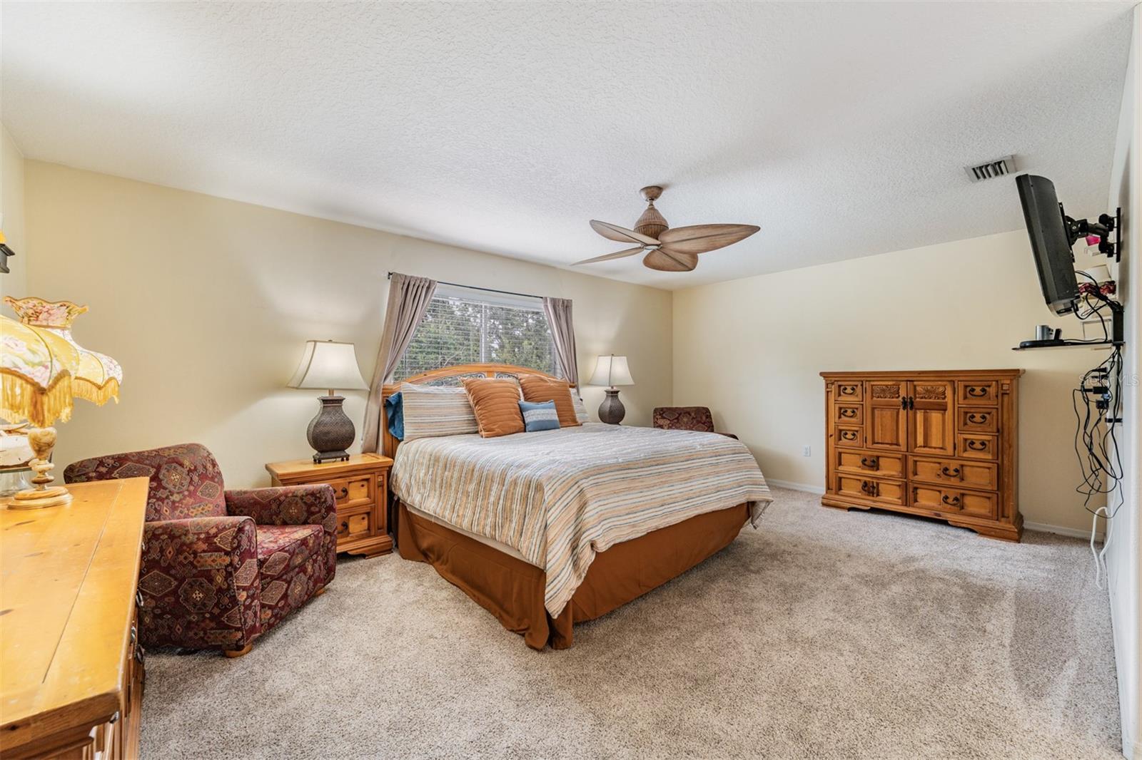 Master Bedroom with Ceiling Fan and newer carpet.