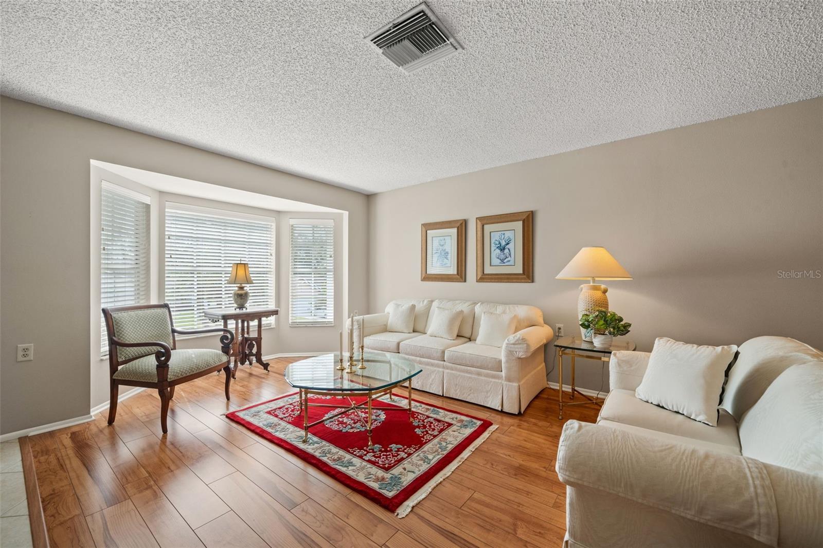 The Living room with a Bay window & laminate flooring.
