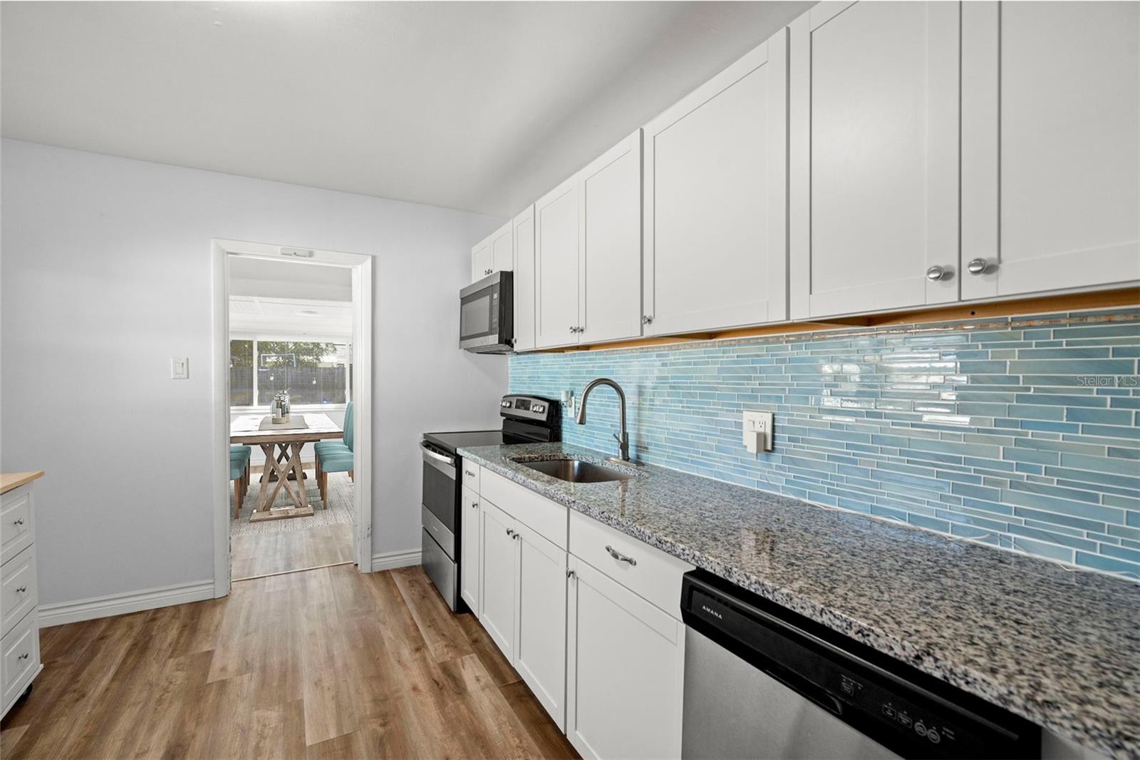 Kitchen with view of dining area and backyard just beyond.