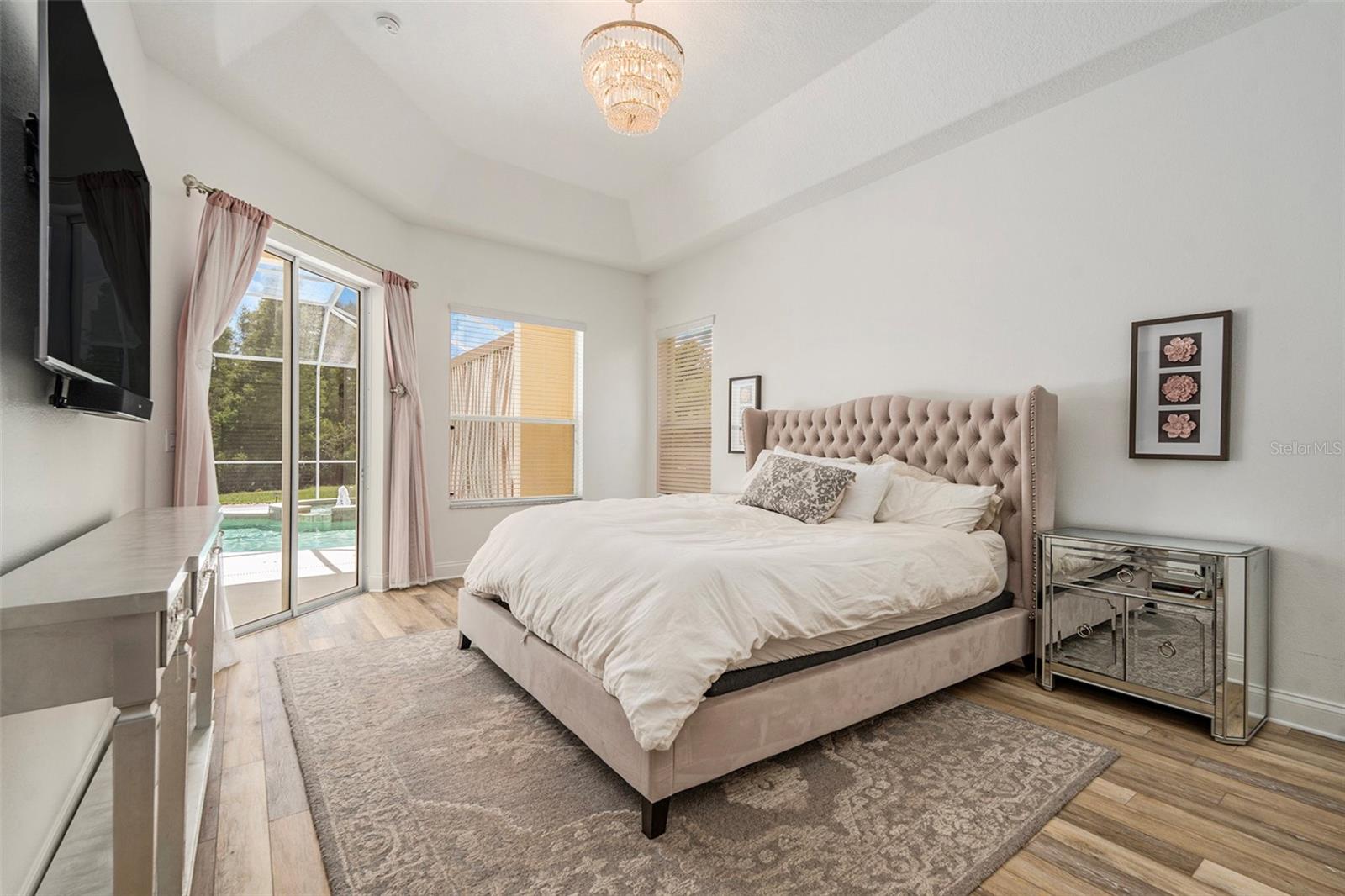 Primary Bedroom with View of Pool, Double Walk-in Closets, and Large En Suite Bathroom