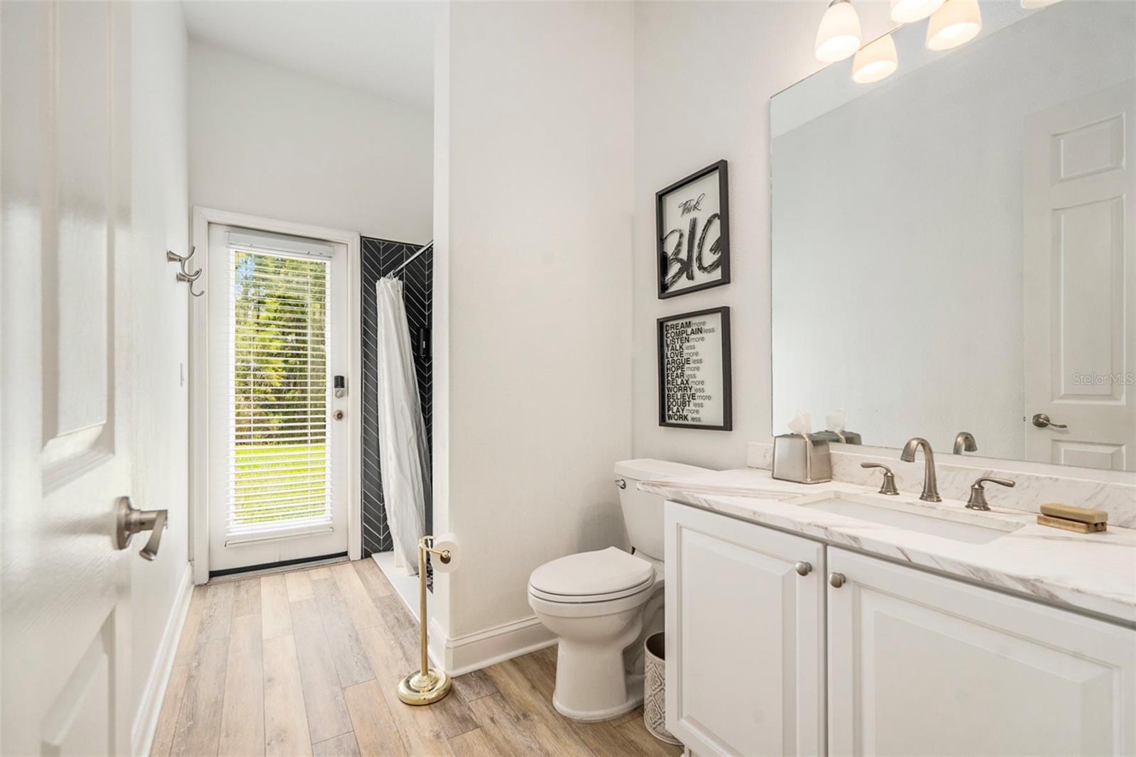 Bathroom with Upgraded Shower Tile and Vanity, as well as Entry to Backyard
