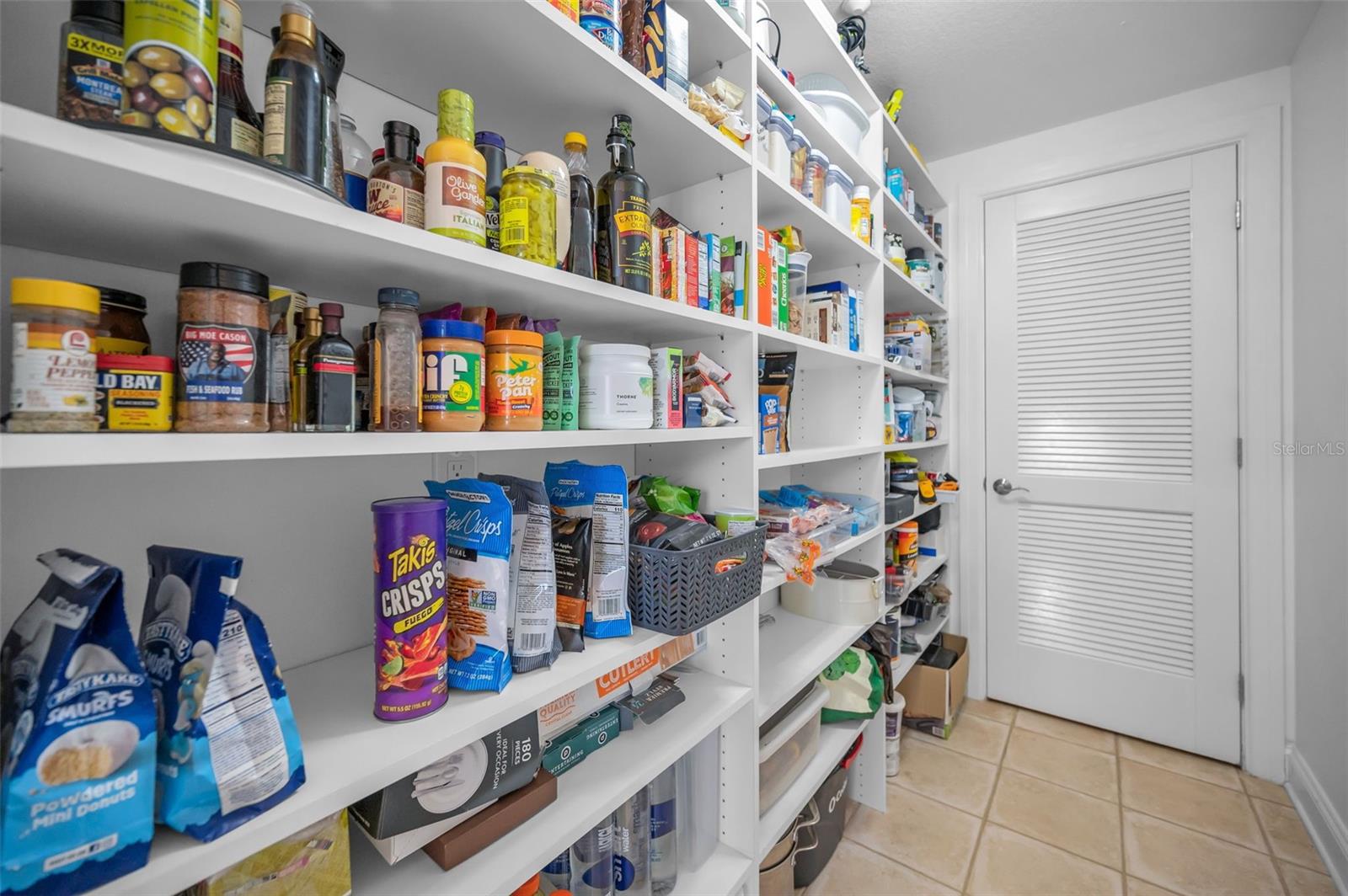 A large walk-in pantry offers space and organization for the items you want hidden.