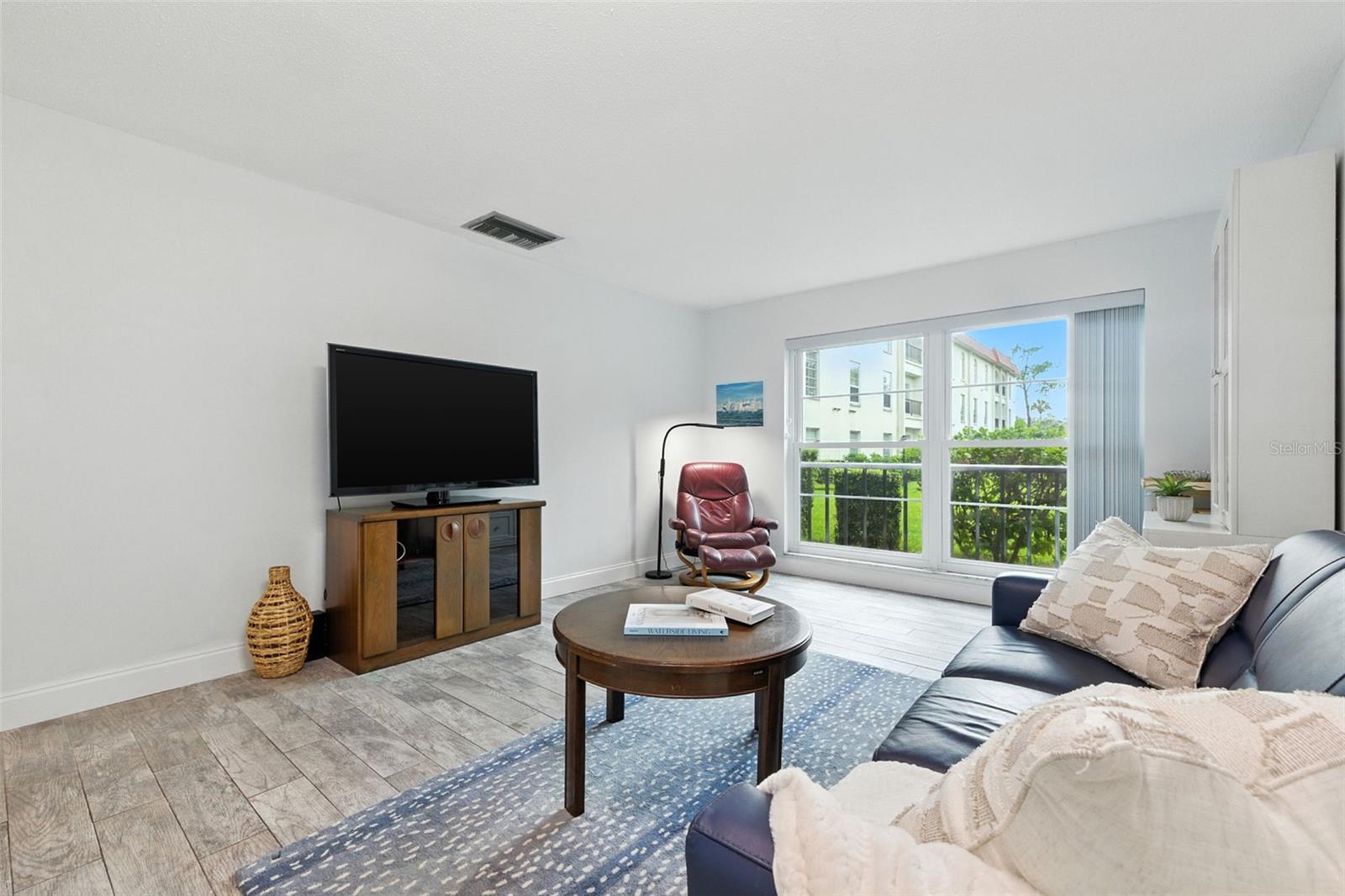 Spacious Living Room with views of the mature trees and shuffleboard courts